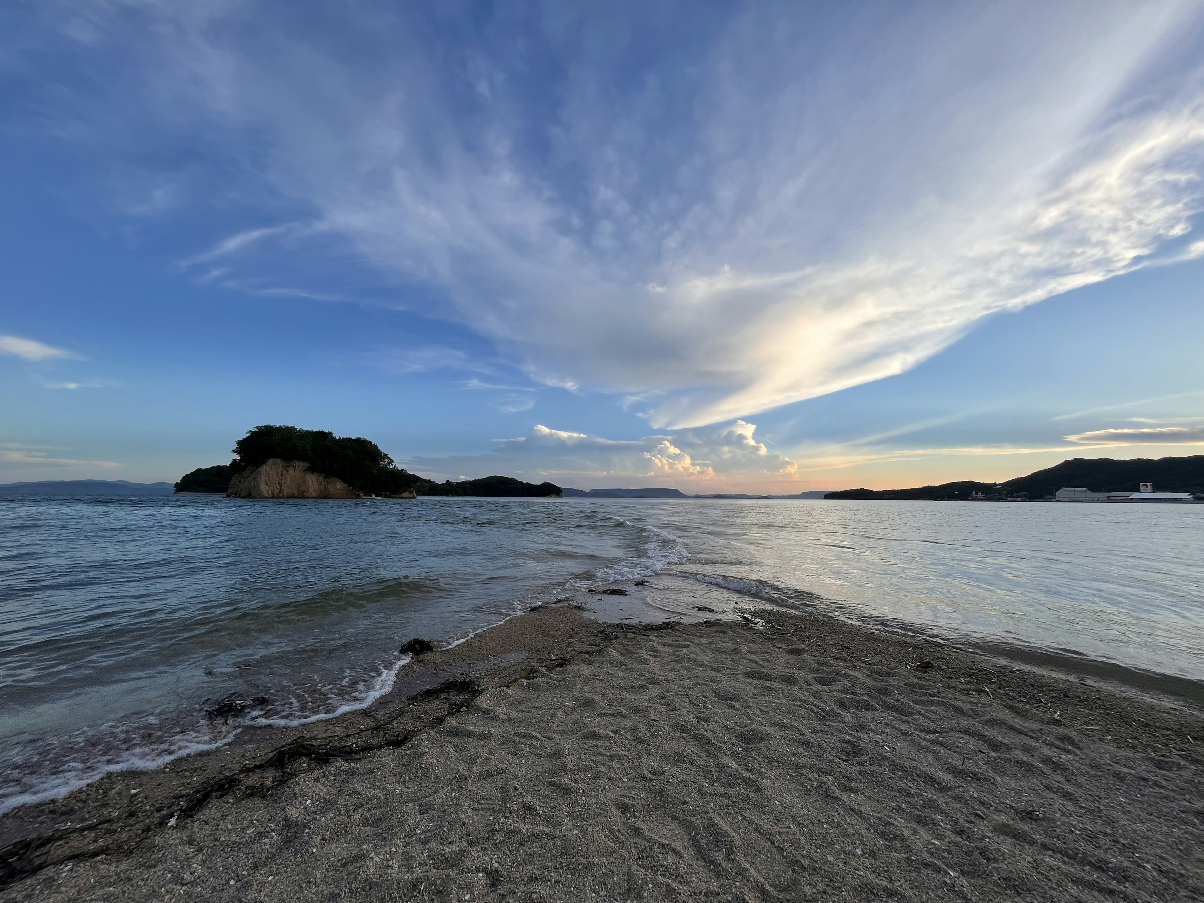 海と空の美しい風景、砂浜と小島が見える