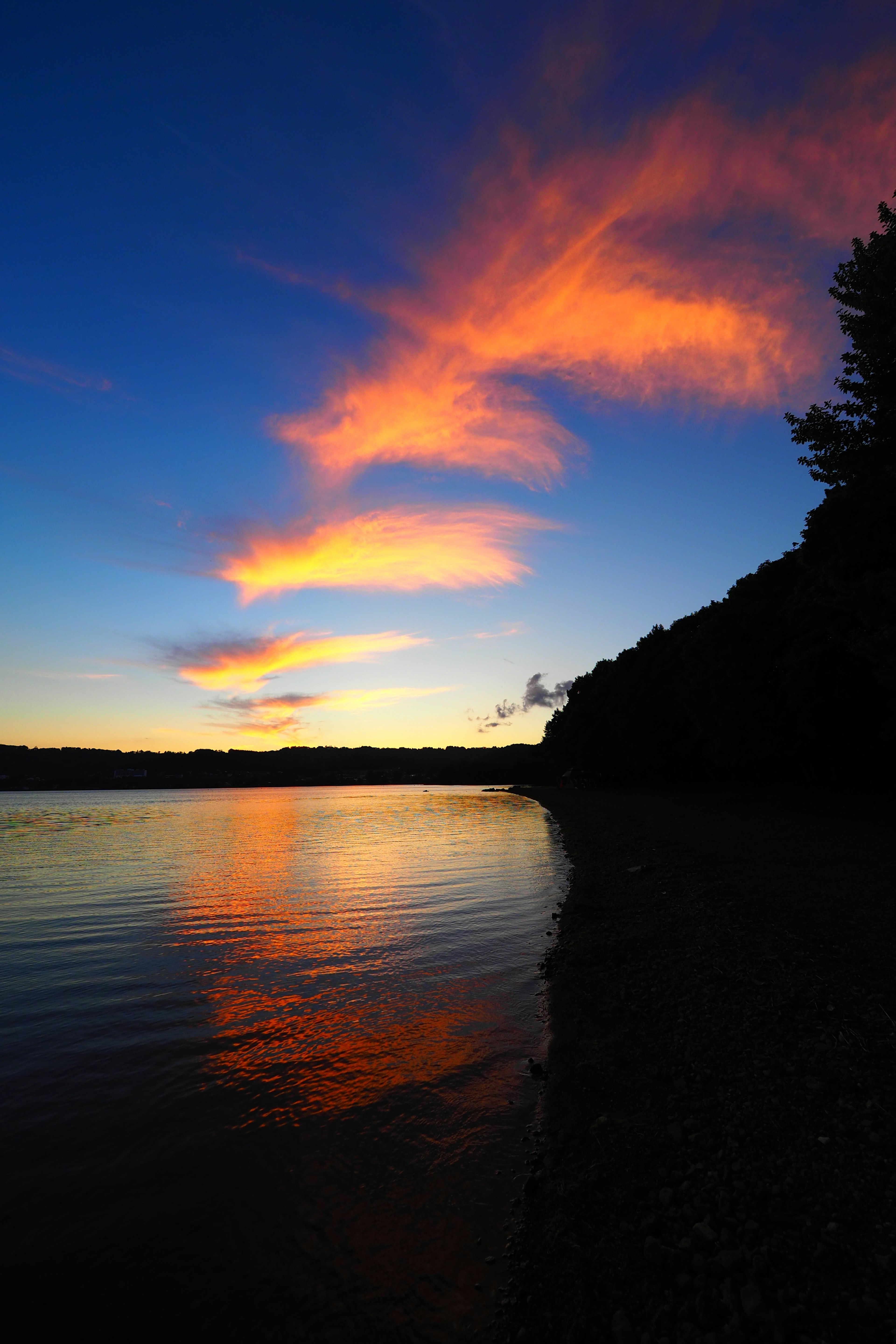 Schöne Landschaft des Sonnenuntergangs, der sich im Wasser spiegelt