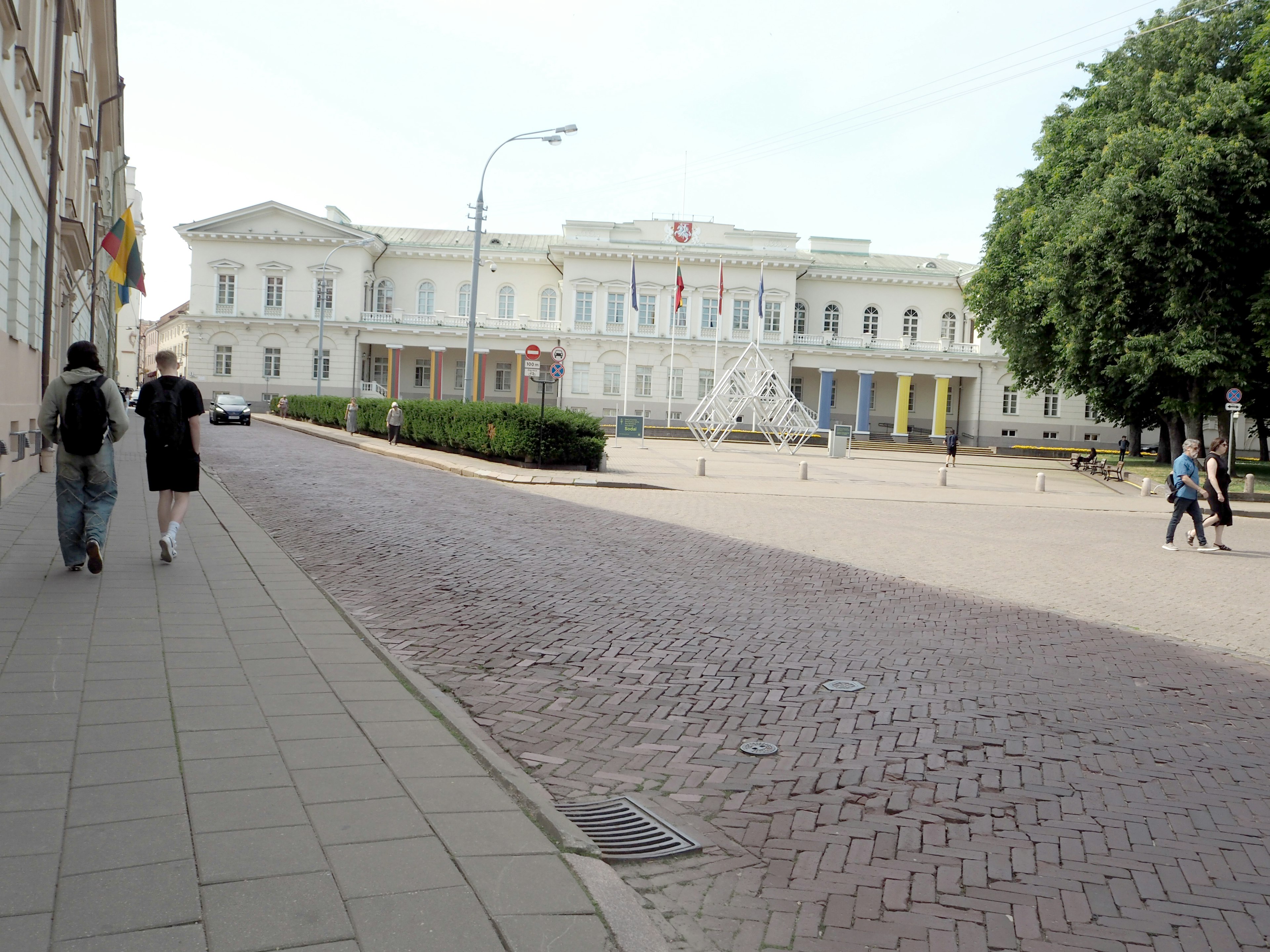 Vista de peatones caminando por una calle con un edificio histórico