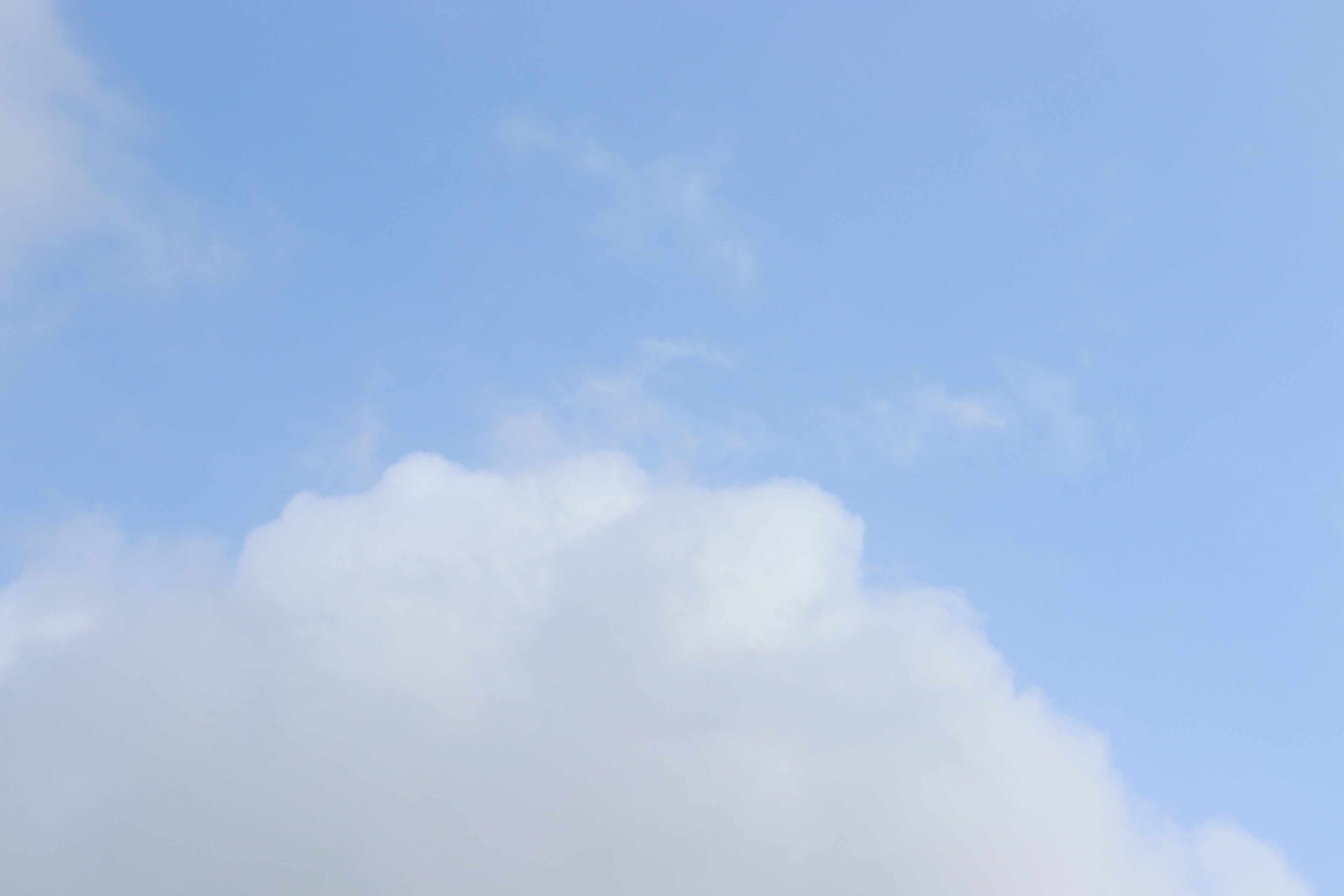 Heller blauer Himmel mit flauschigen weißen Wolken