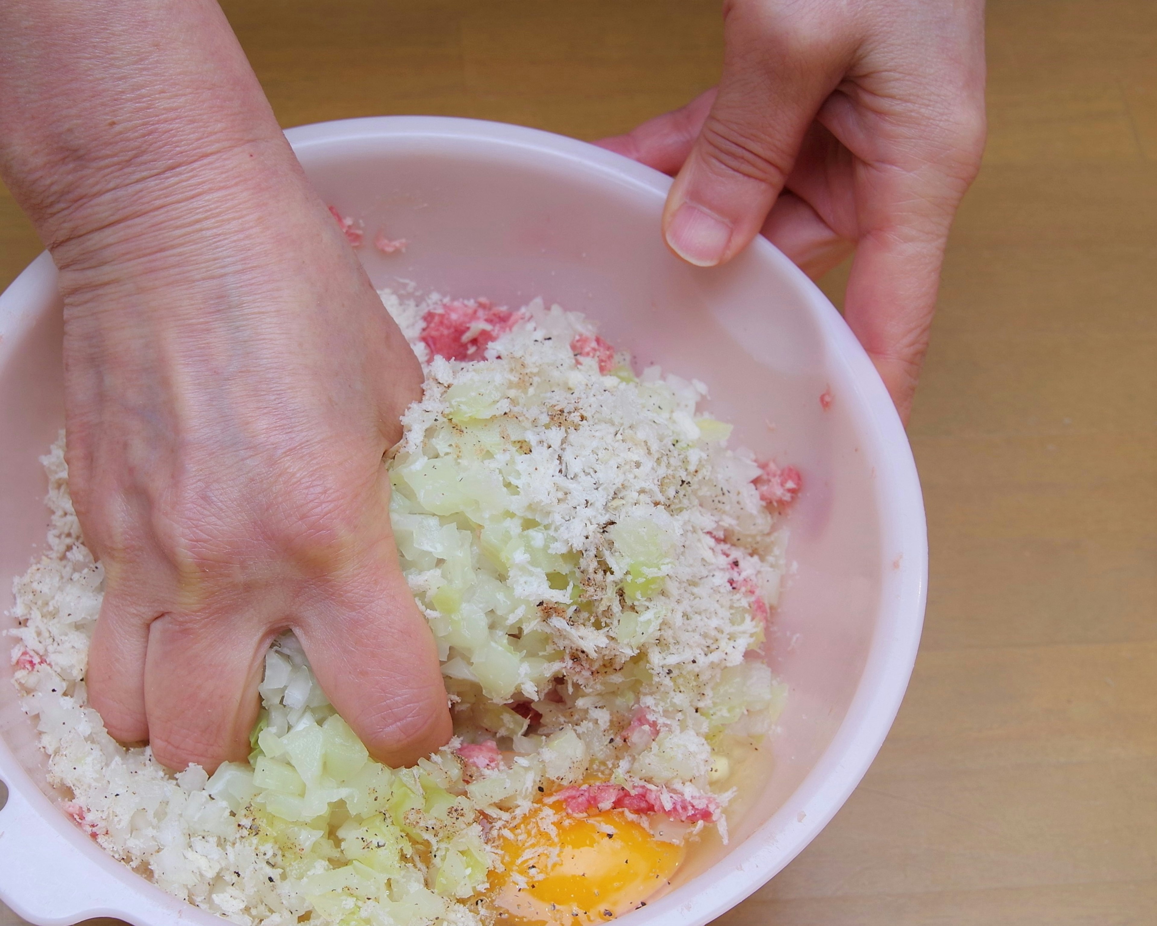 Hands mixing ingredients in a bowl