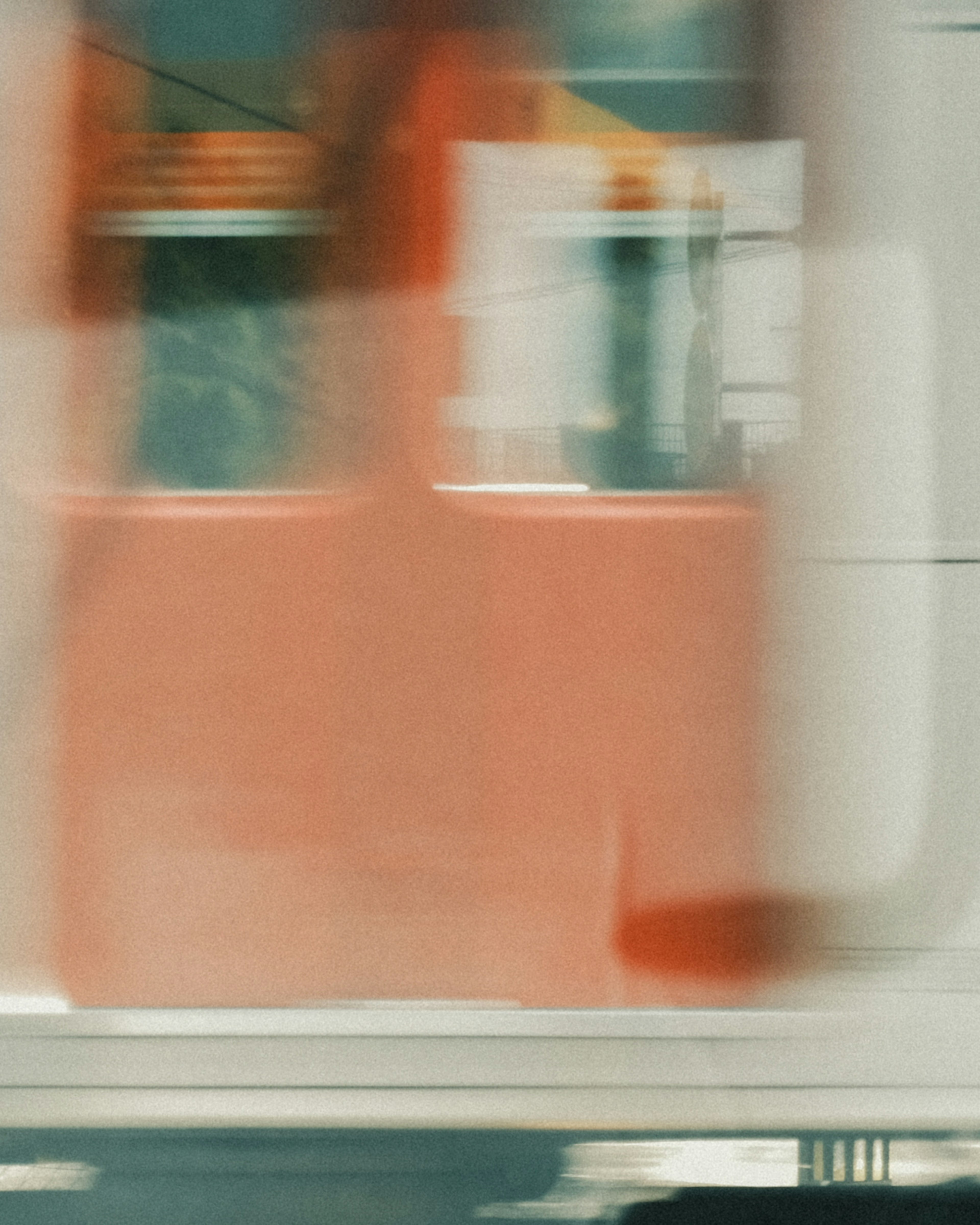 Blurred background featuring a red wall and window of a moving train