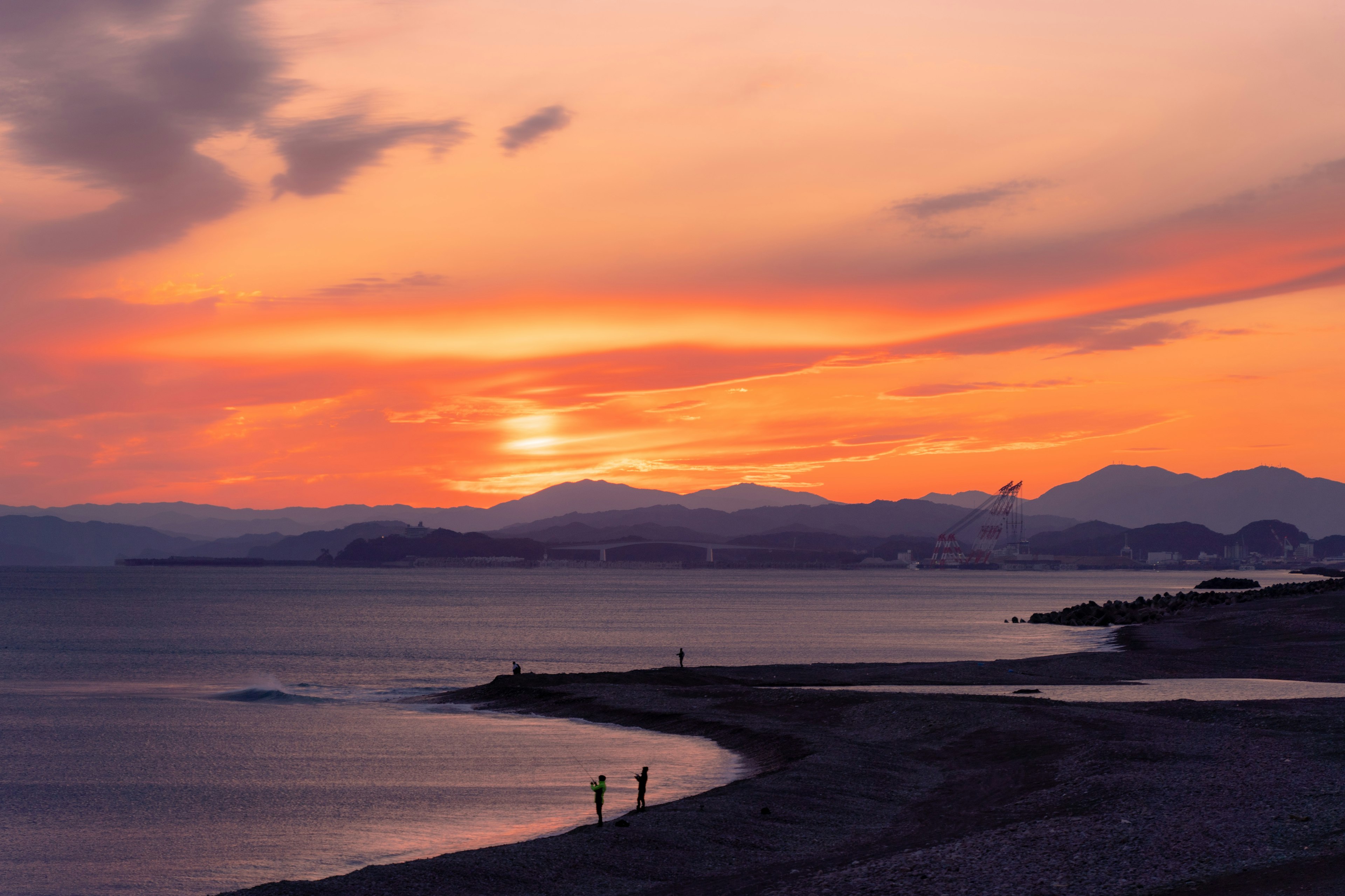 Coucher de soleil pittoresque sur l'océan avec des silhouettes de montagnes en arrière-plan