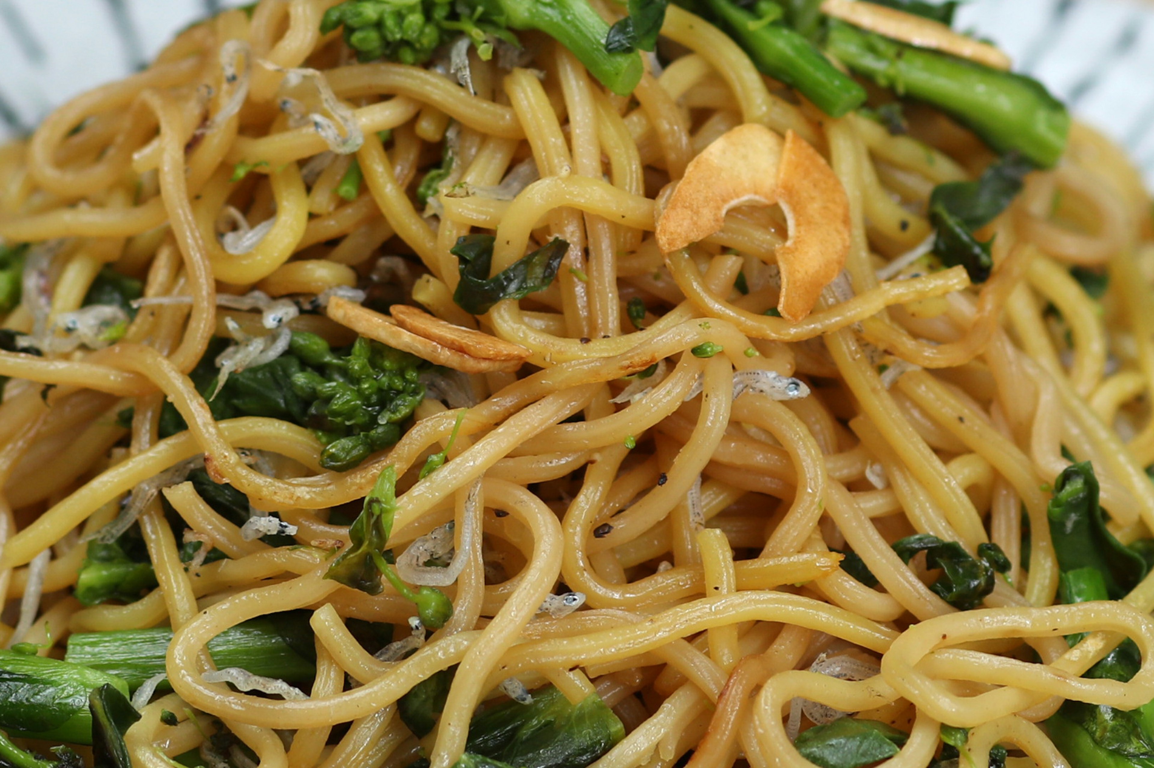 Stir-fried noodles topped with broccoli and nuts