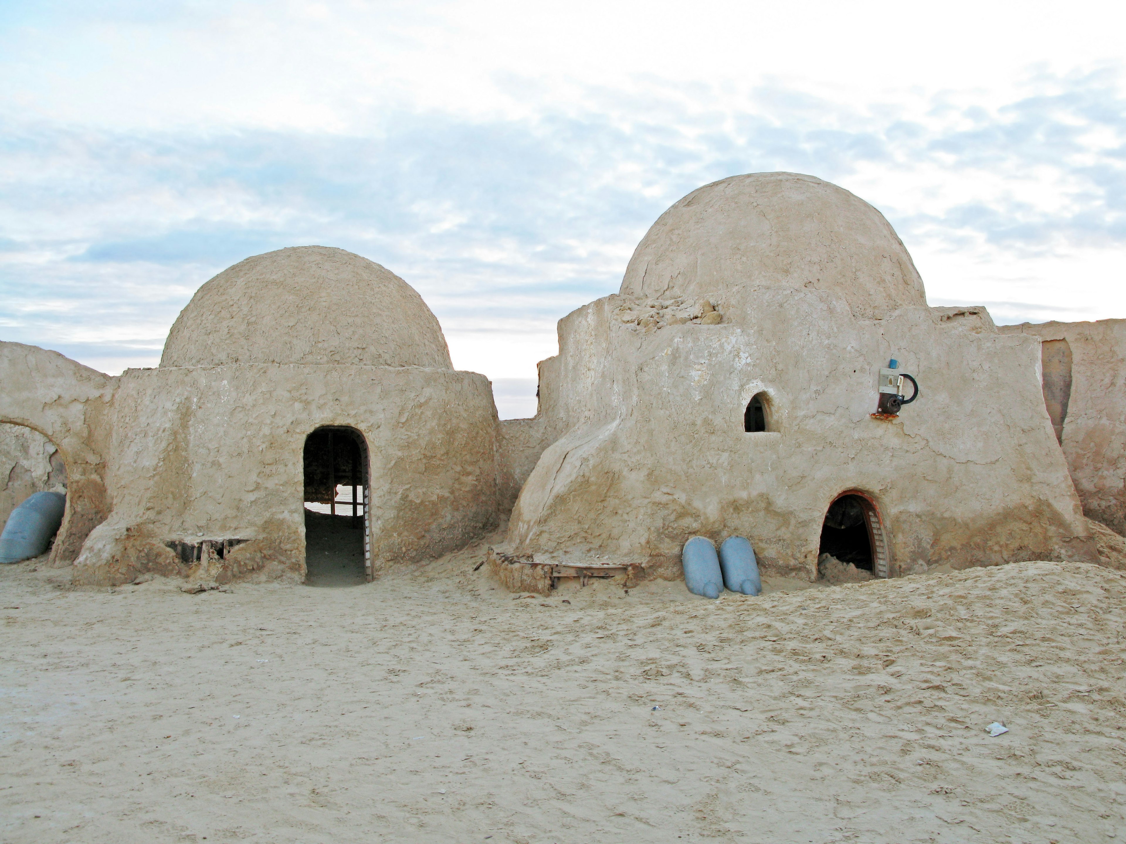 Two traditional mud houses in a desert landscape