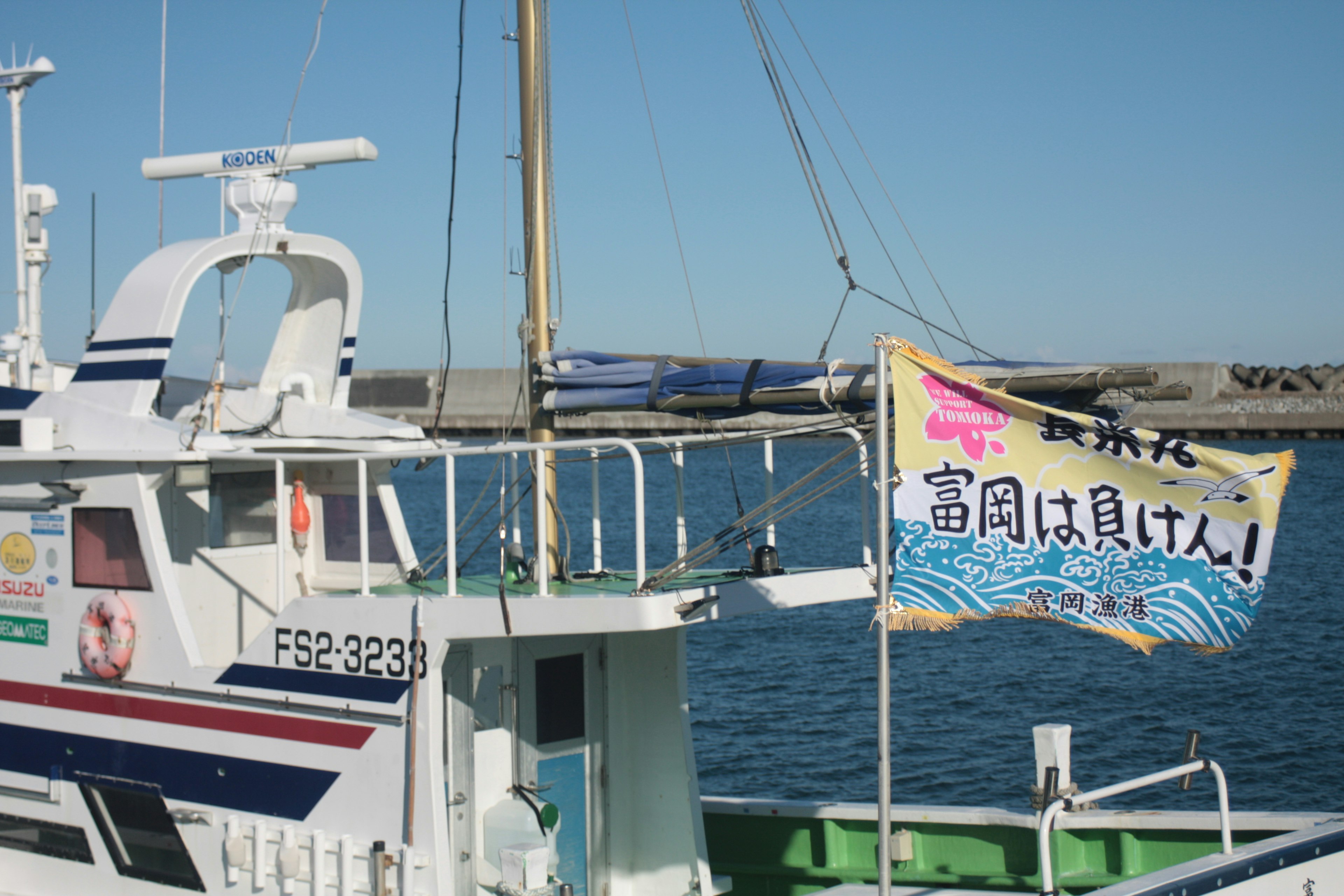 Peschereccio con bandiera colorata e mare blu