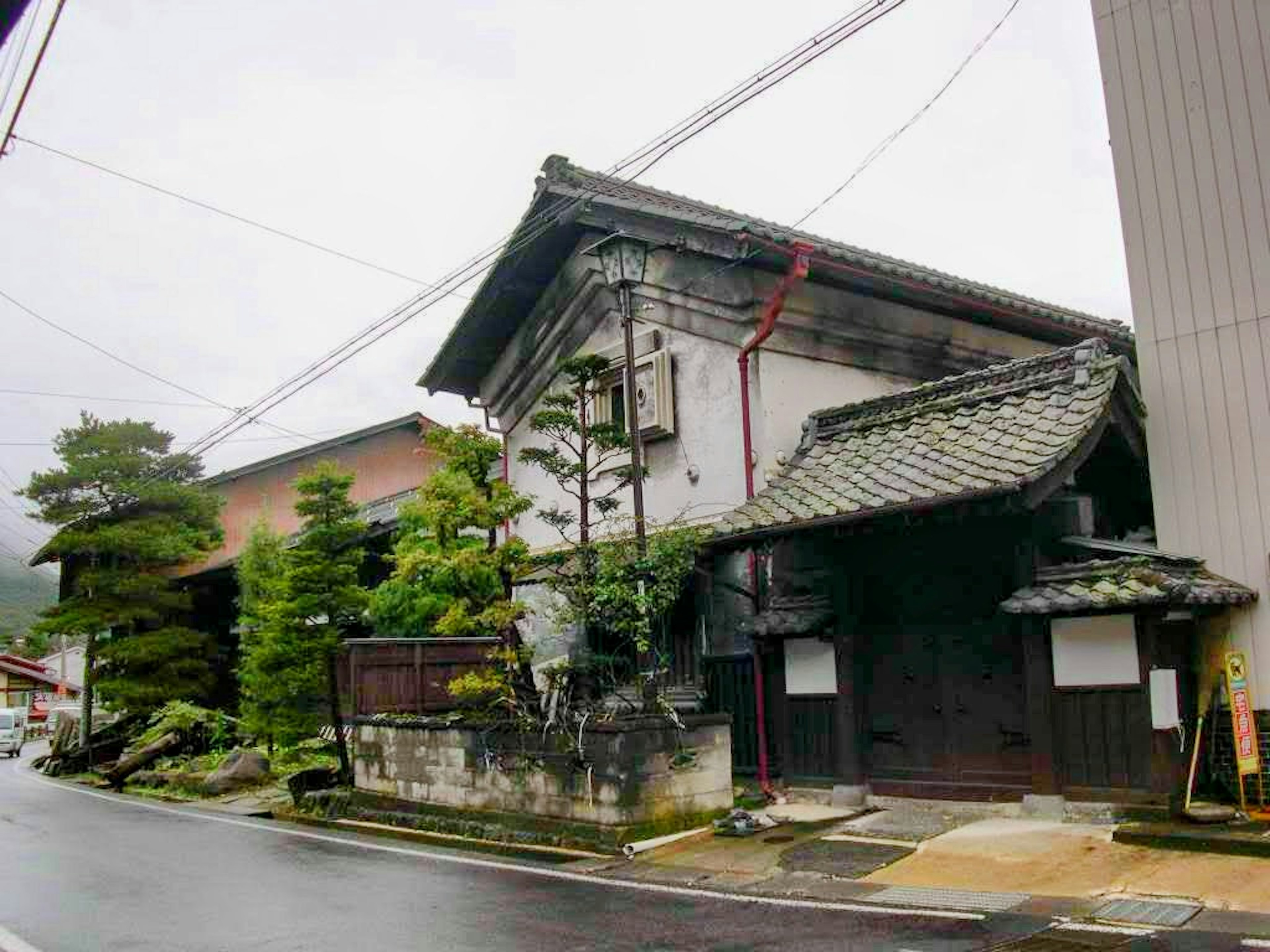 Casa japonesa antigua y escena de jardín en un día lluvioso