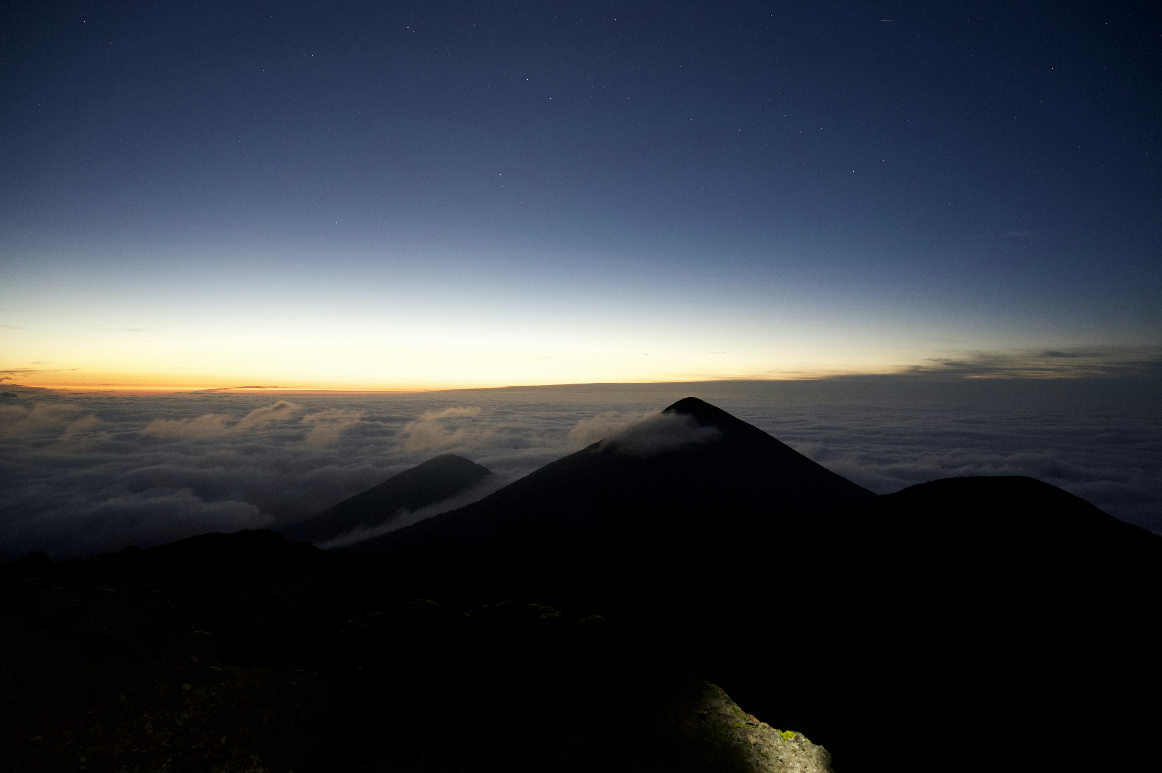 山のシルエットが浮かぶ夜明け前の風景