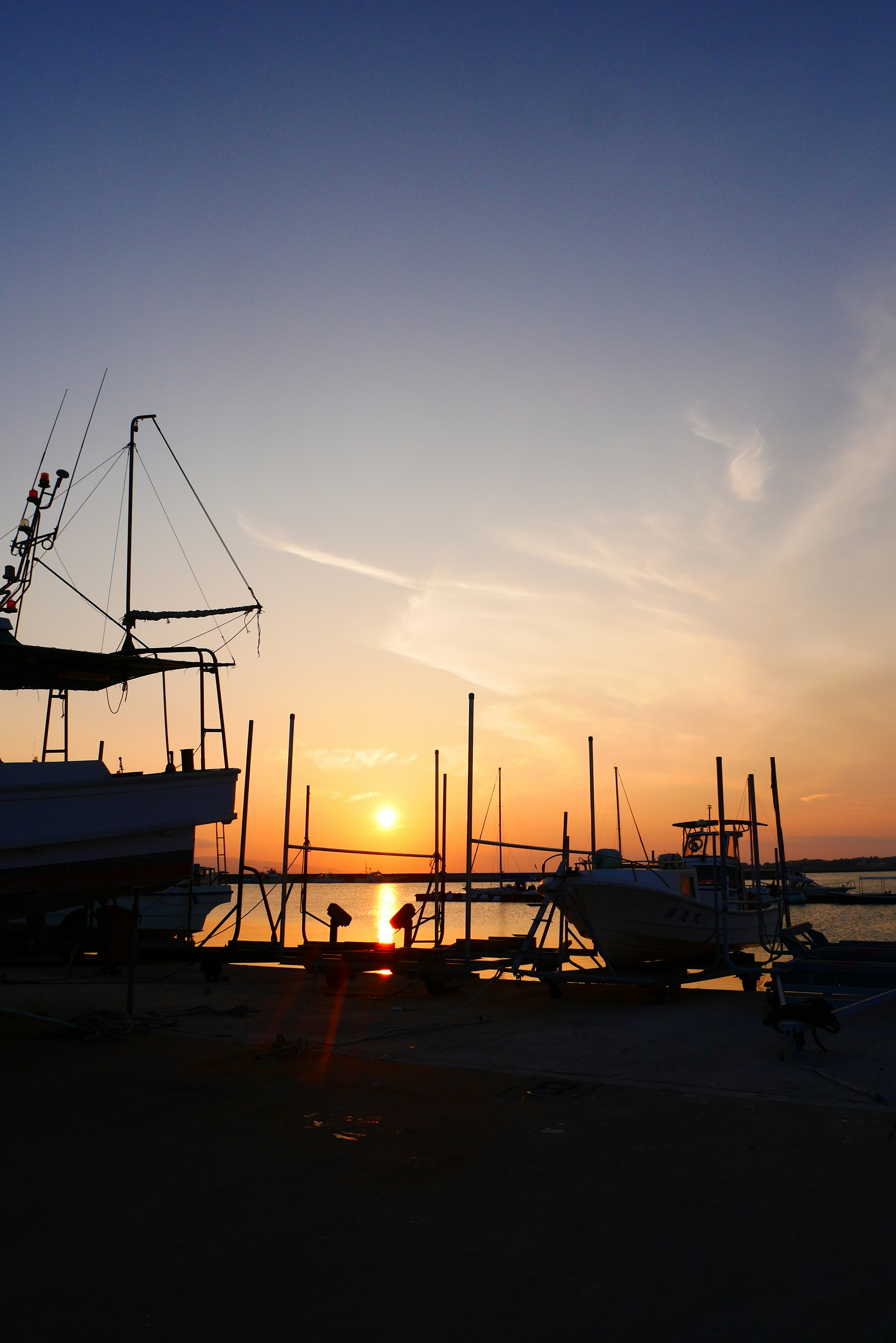 Silhouette von Booten in einem Hafen bei Sonnenuntergang