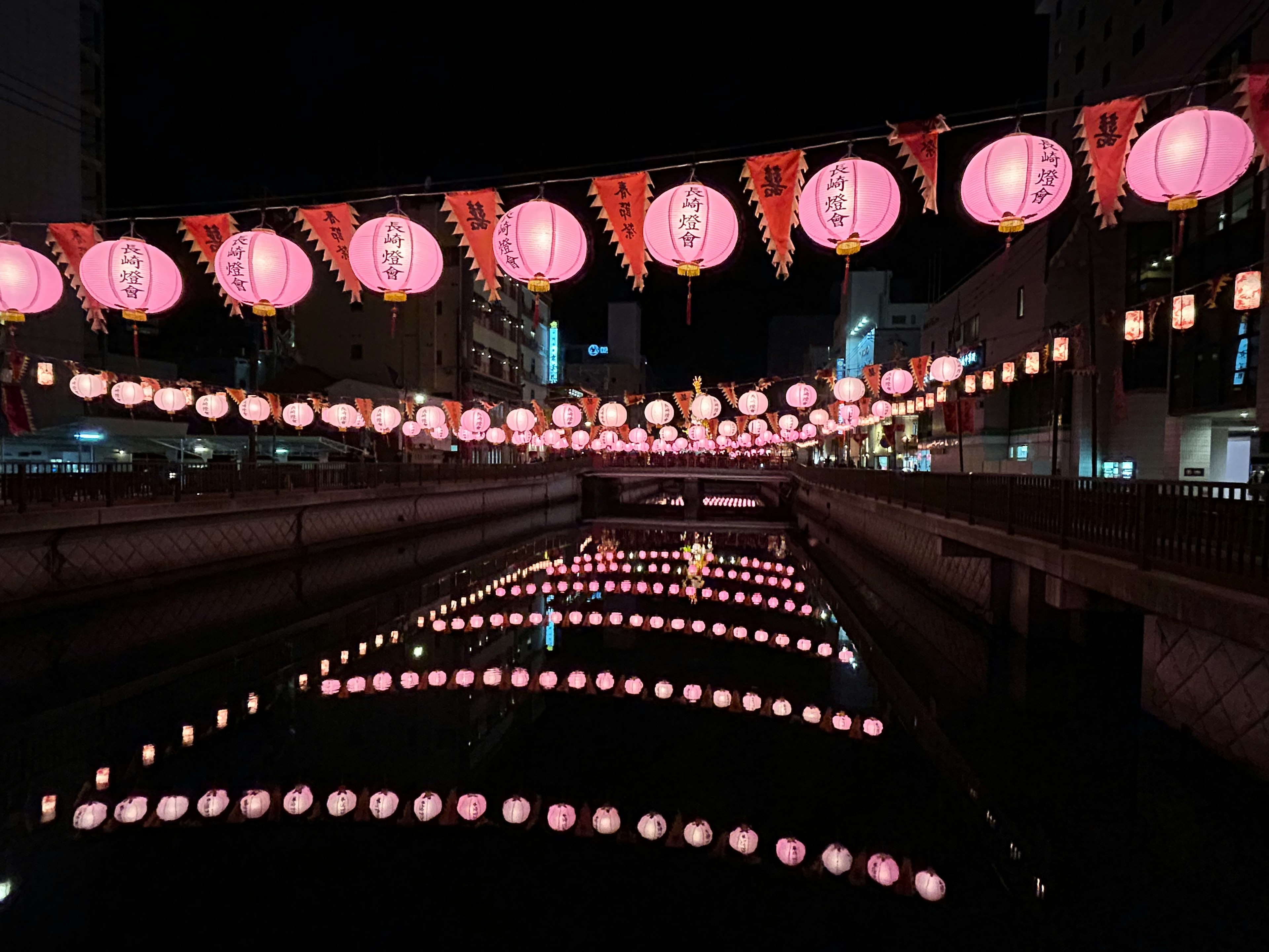 Bellissimo scenario di lanterne rosa che galleggiano su un fiume di notte