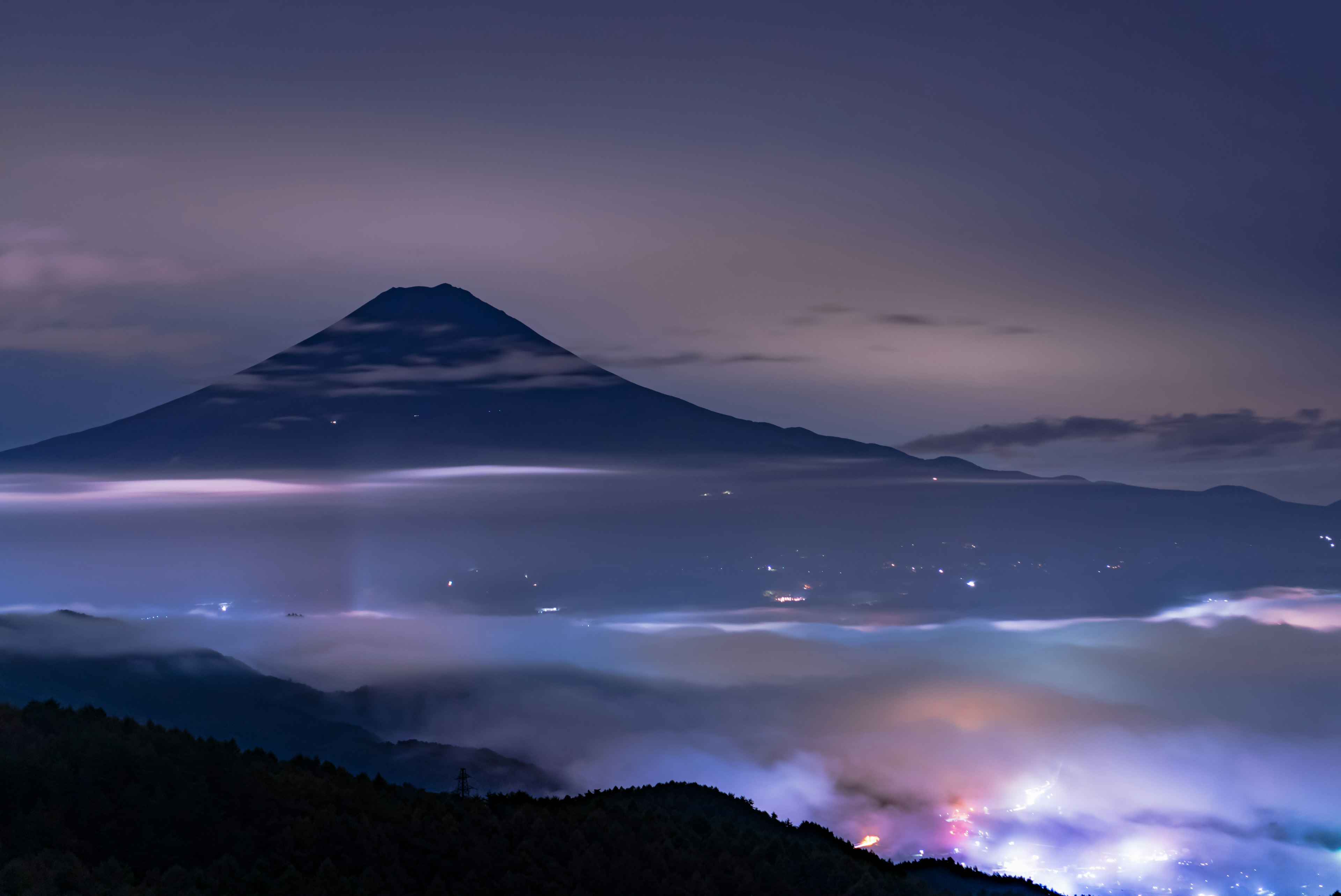 黃昏天空下的山脈輪廓與霧氣瀰漫的山谷