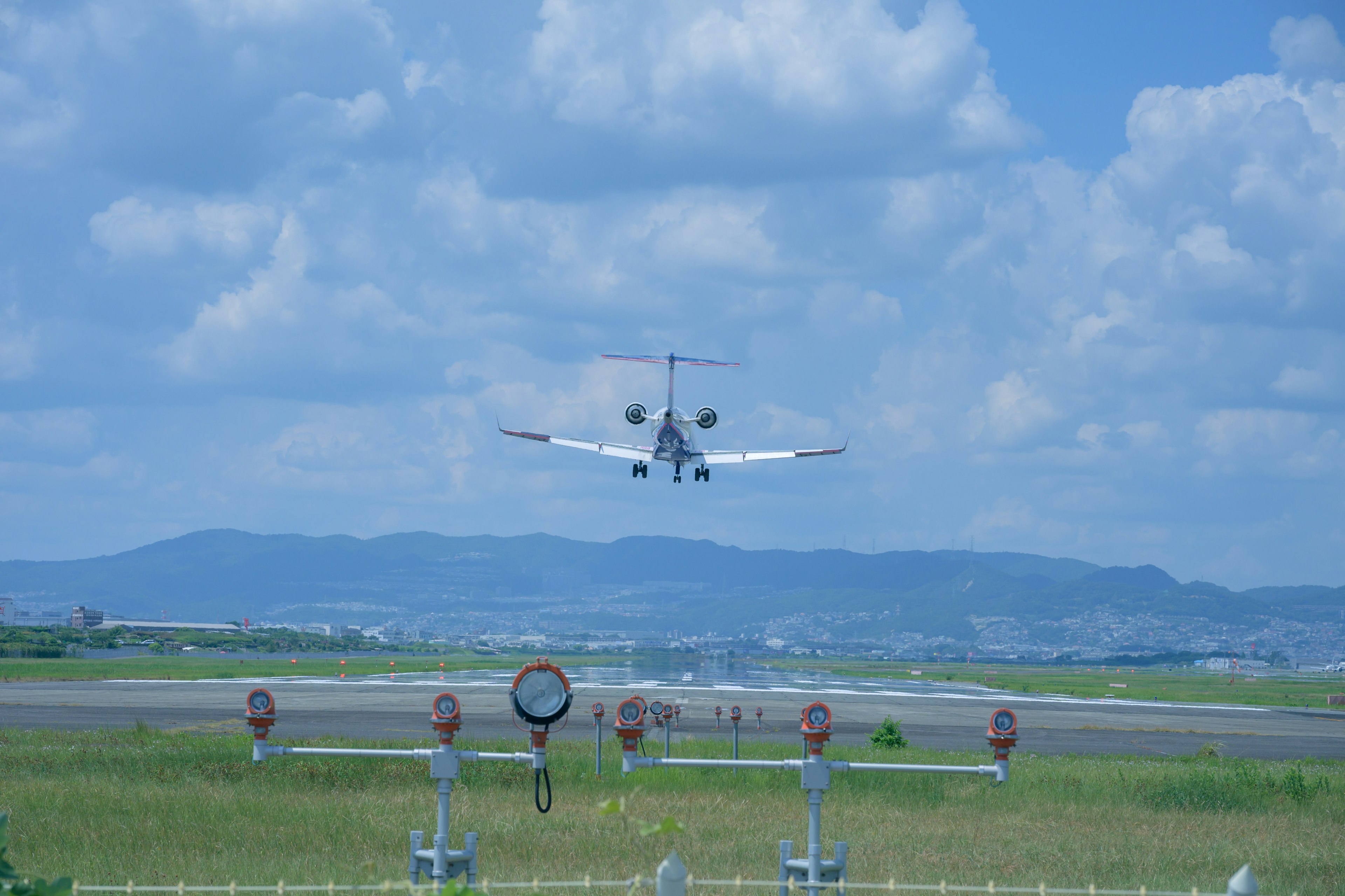 青空の下で着陸する飛行機と滑走路の風景