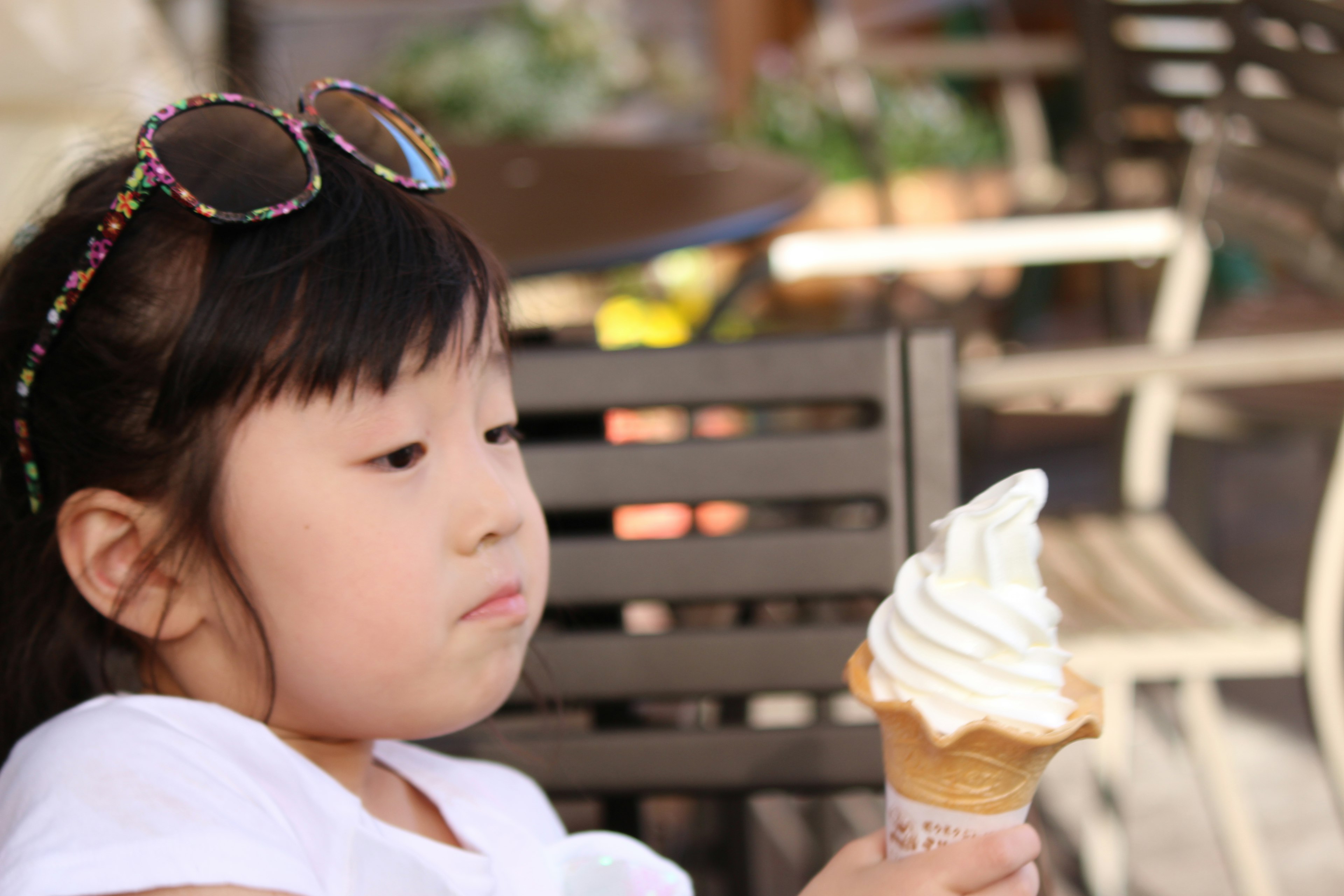 Ragazza in camicia bianca che tiene un cono gelato