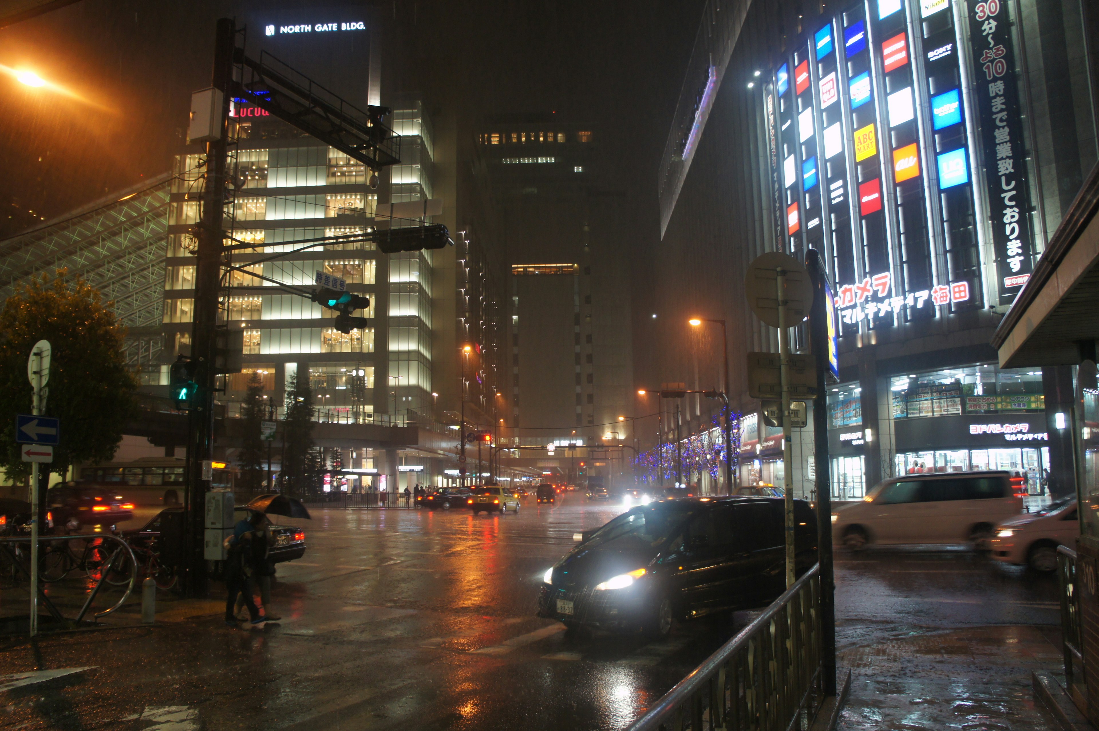 Paysage urbain sous la pluie avec des voitures et des bâtiments illuminés