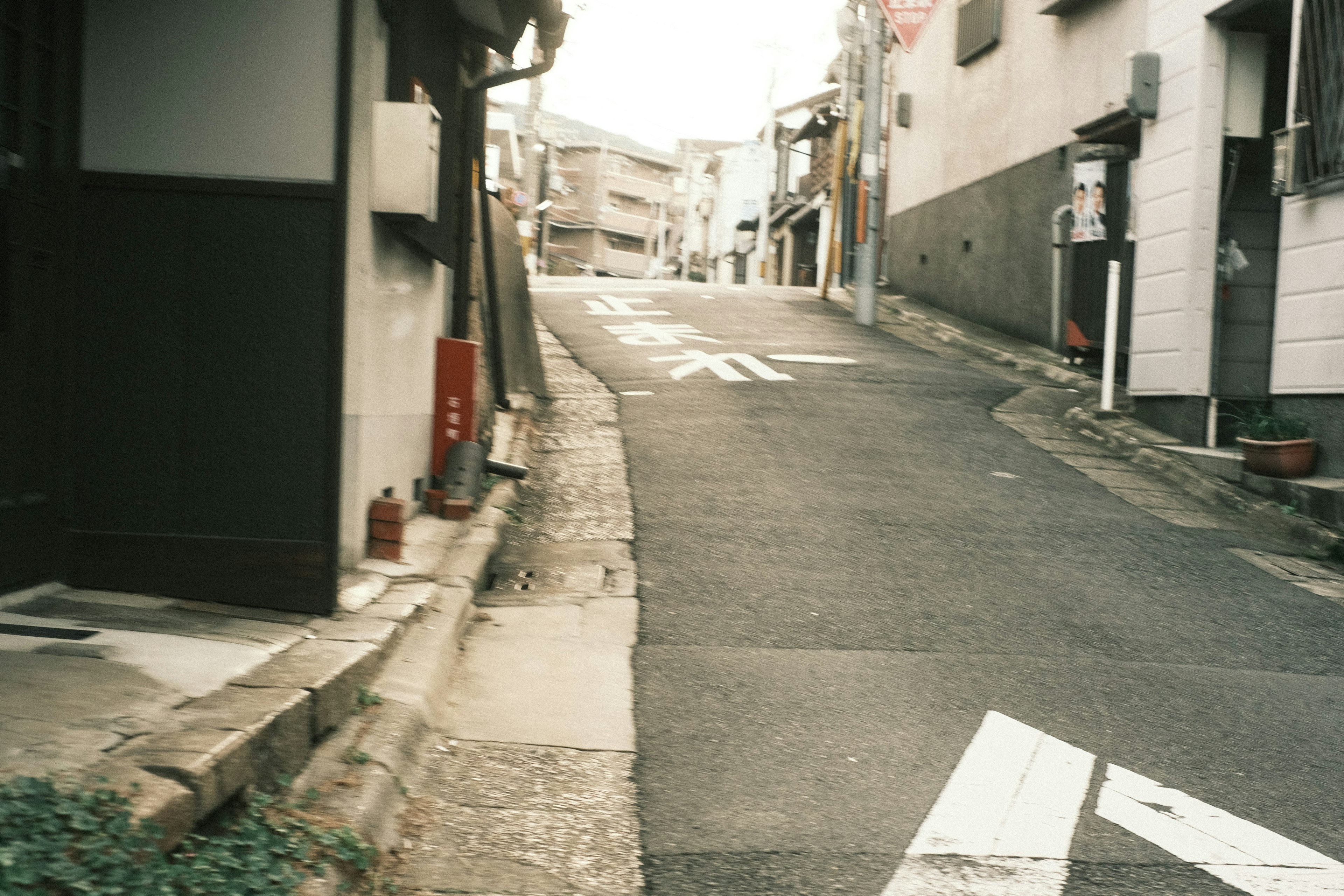 狭い坂道と古い建物が並ぶ景色