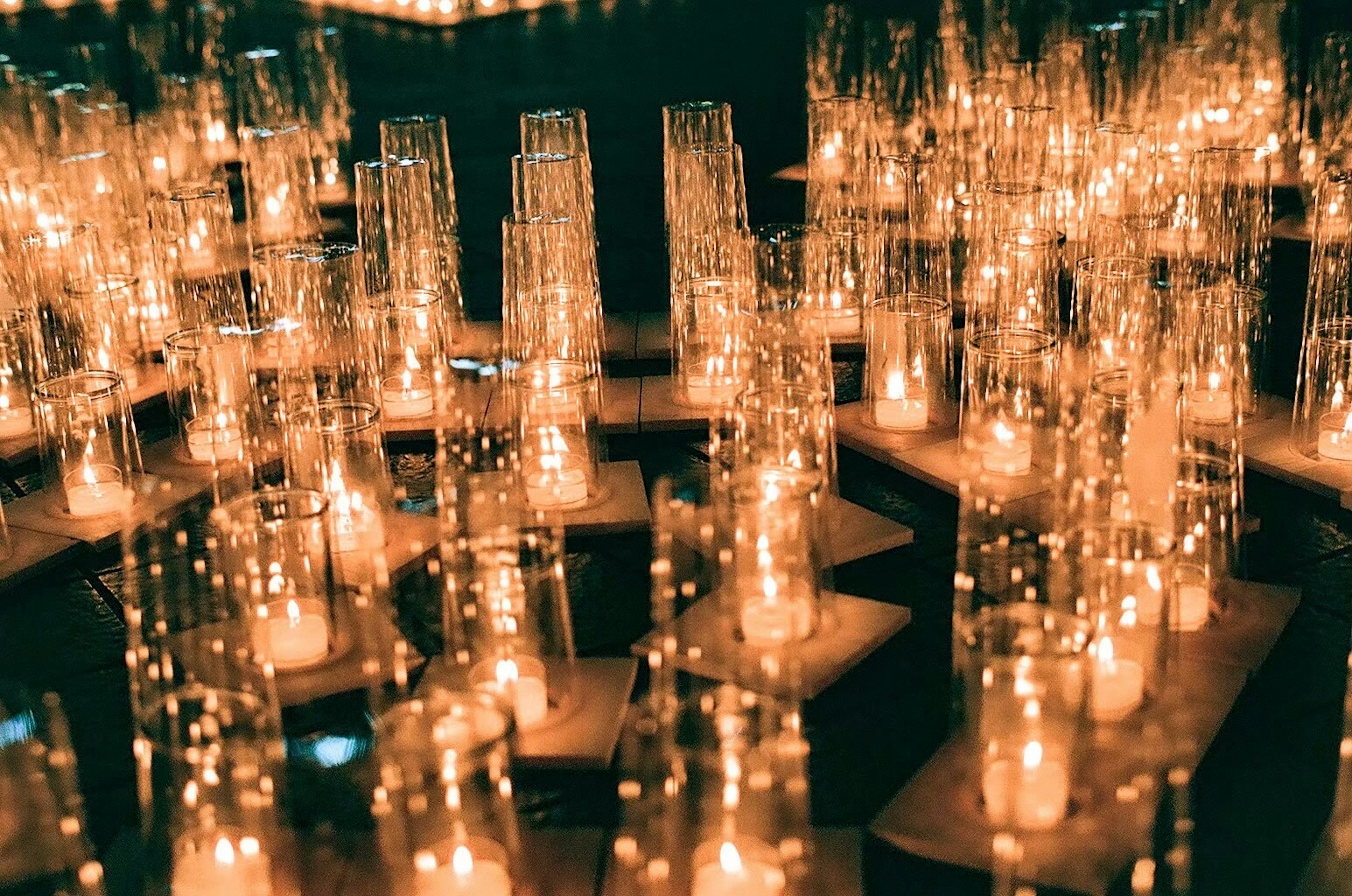 A cluster of glowing candles arranged on a dark background