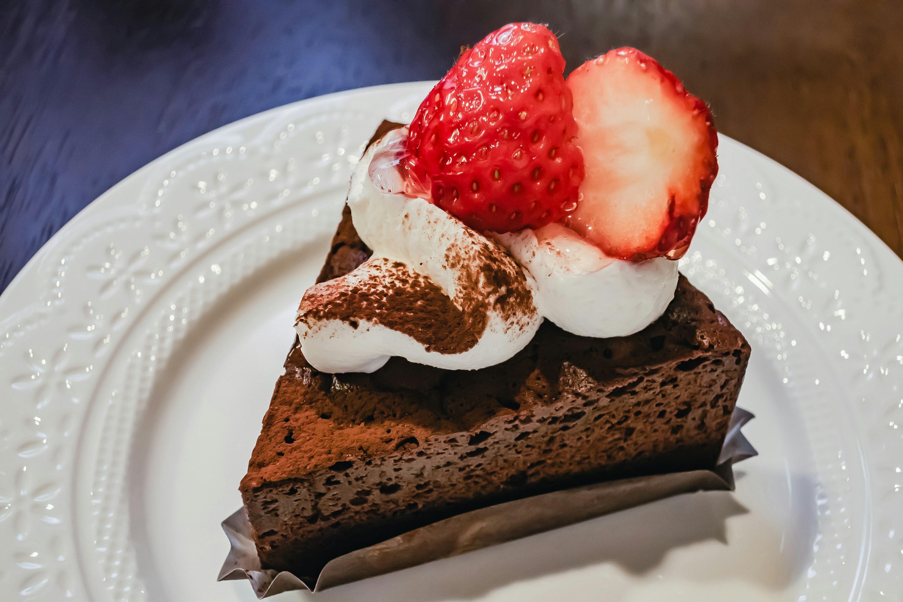 Pastel de chocolate cubierto con crema batida y fresas