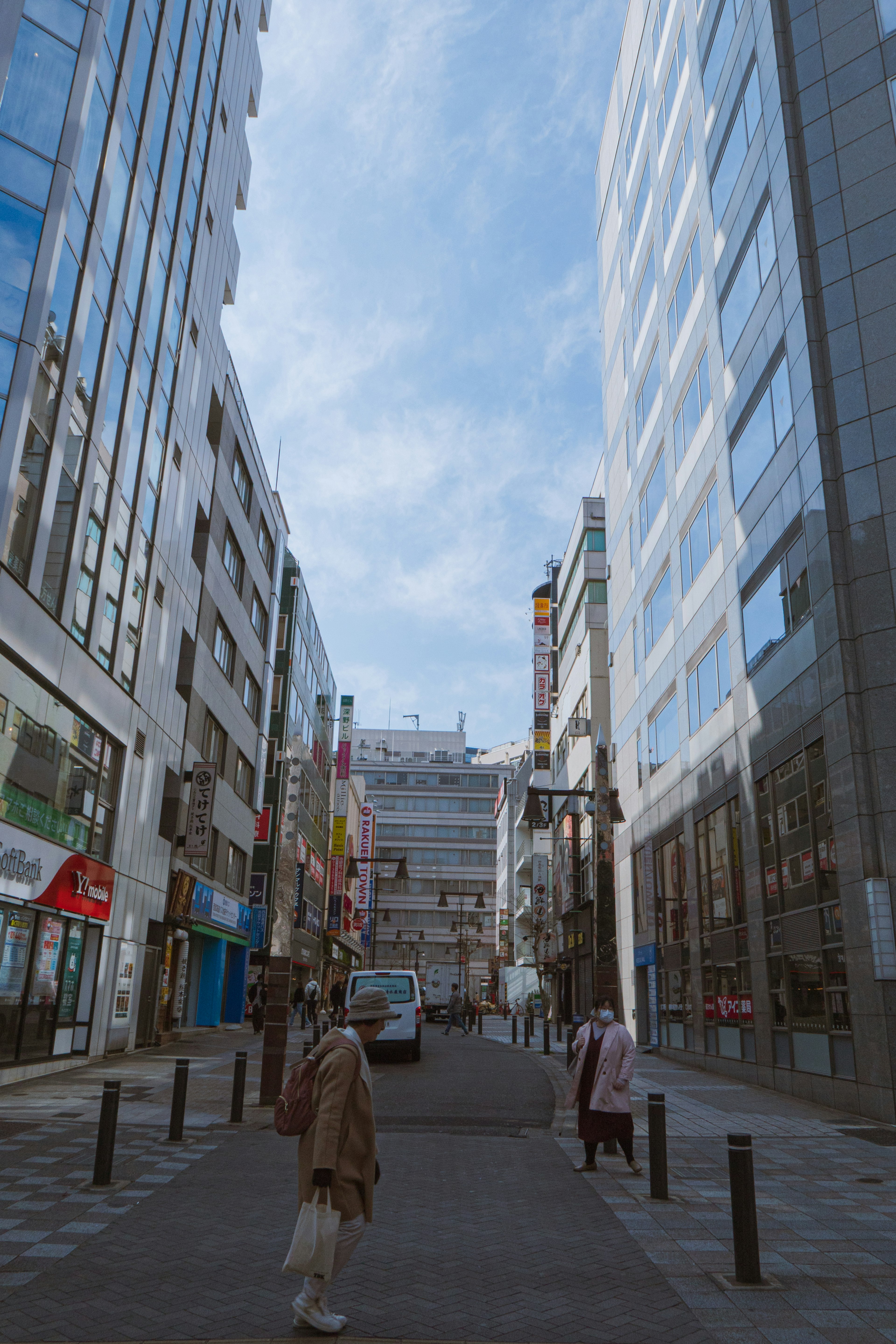 高層ビルに囲まれた街並みで人々が歩いている様子