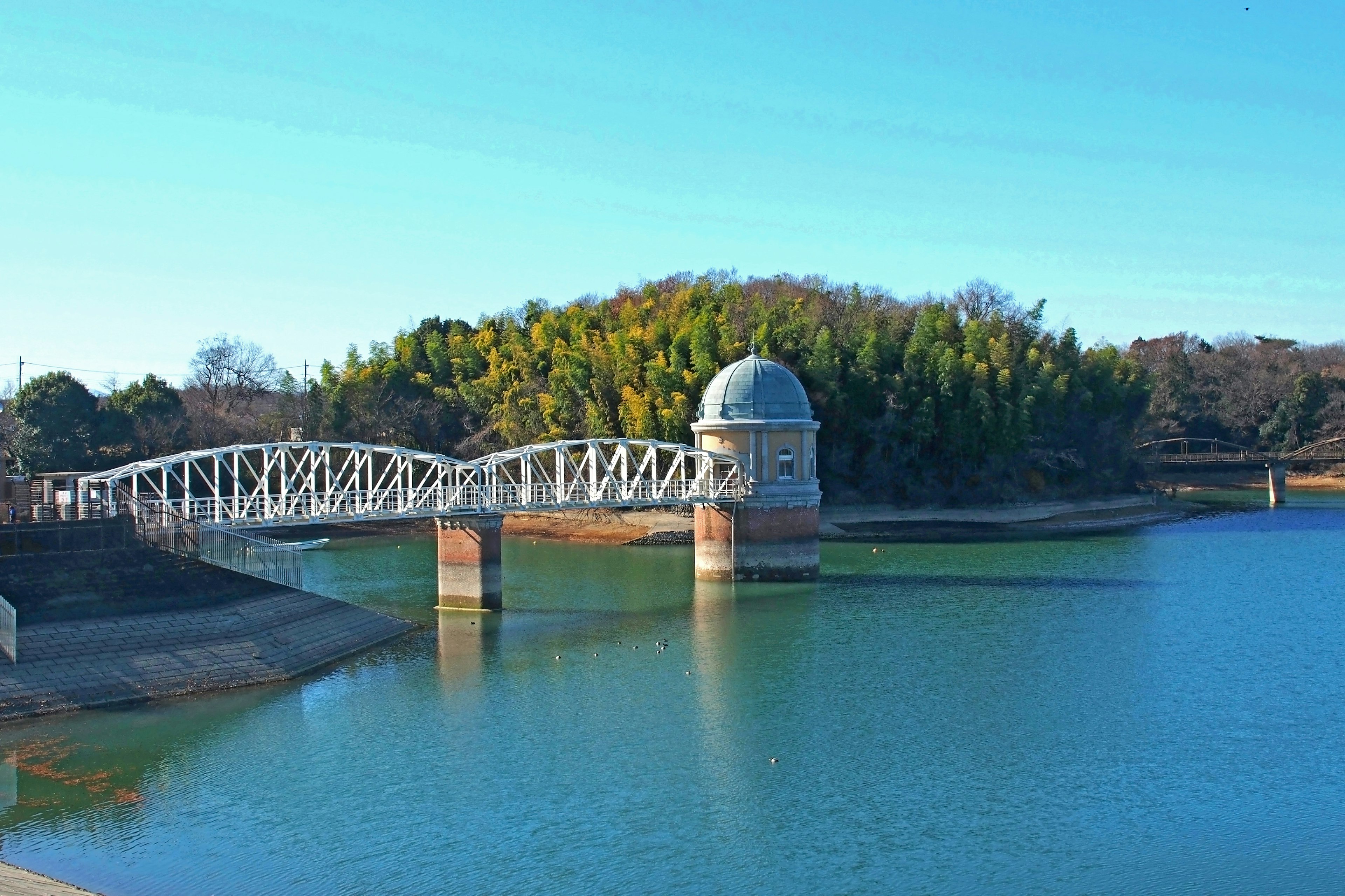 Vista panoramica di un ponte bianco su un serbatoio sotto un cielo blu