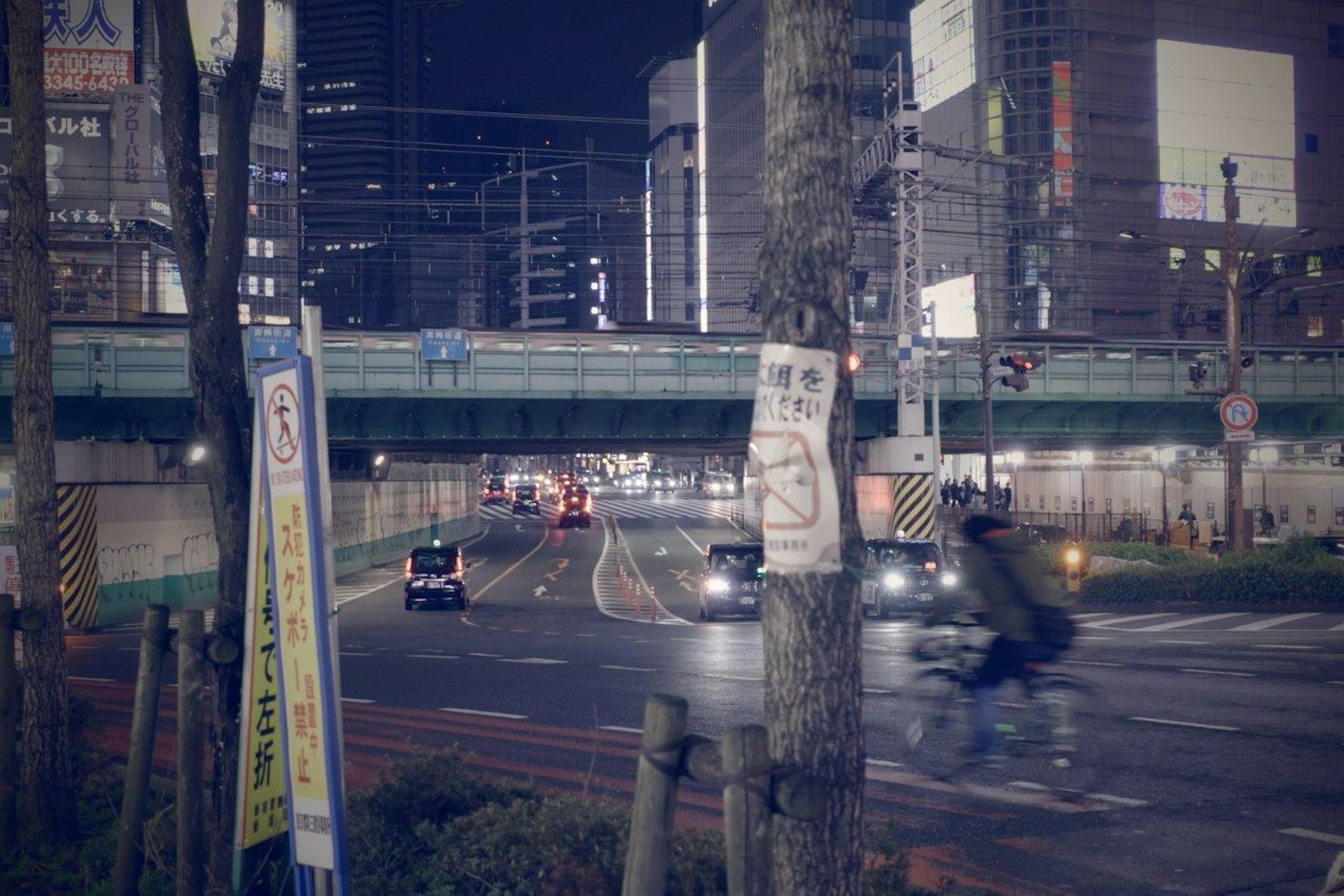 夜の都市風景車両と自転車が行き交う橋の下