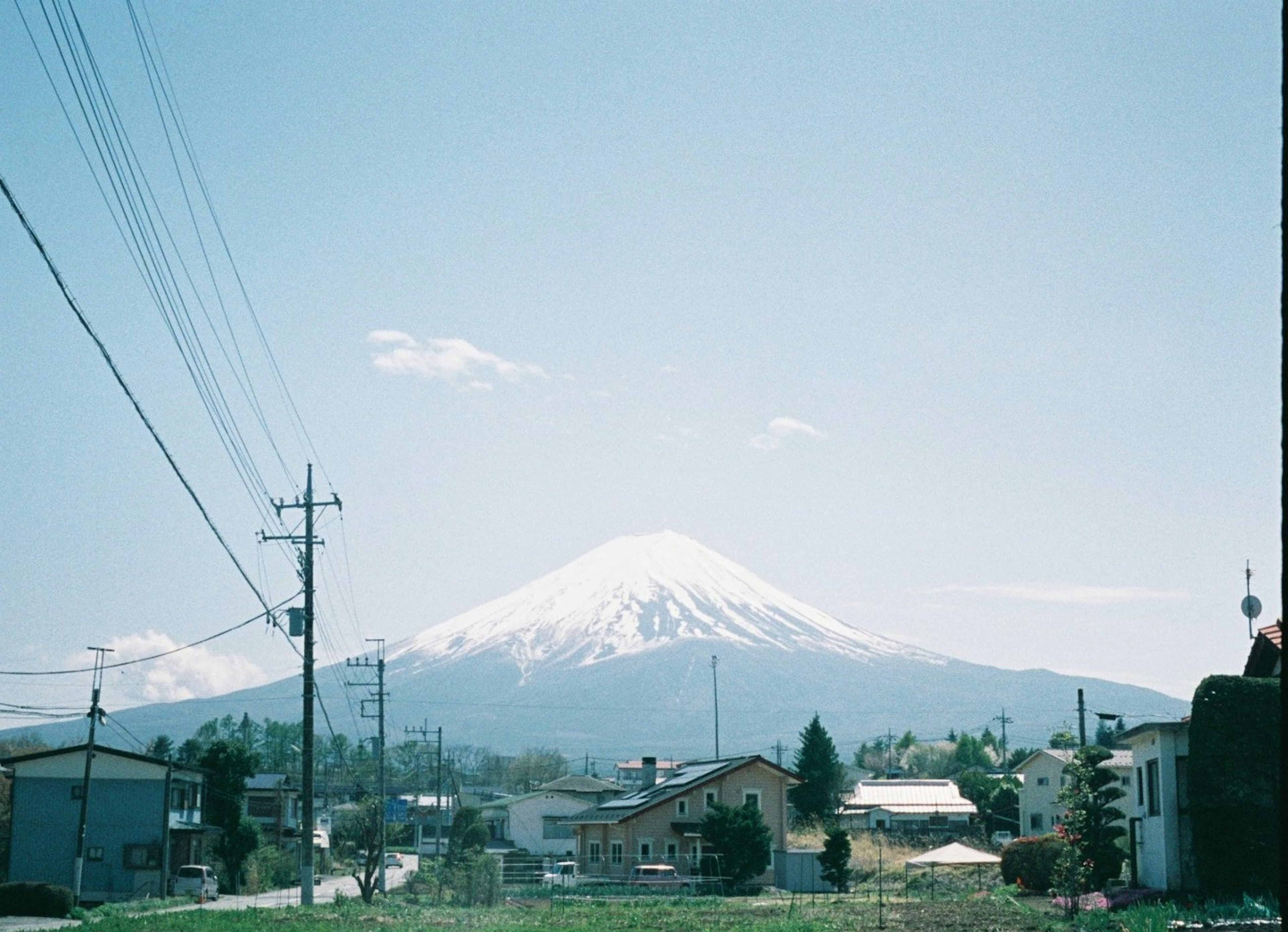 青空の下に雪をかぶった富士山が見える風景