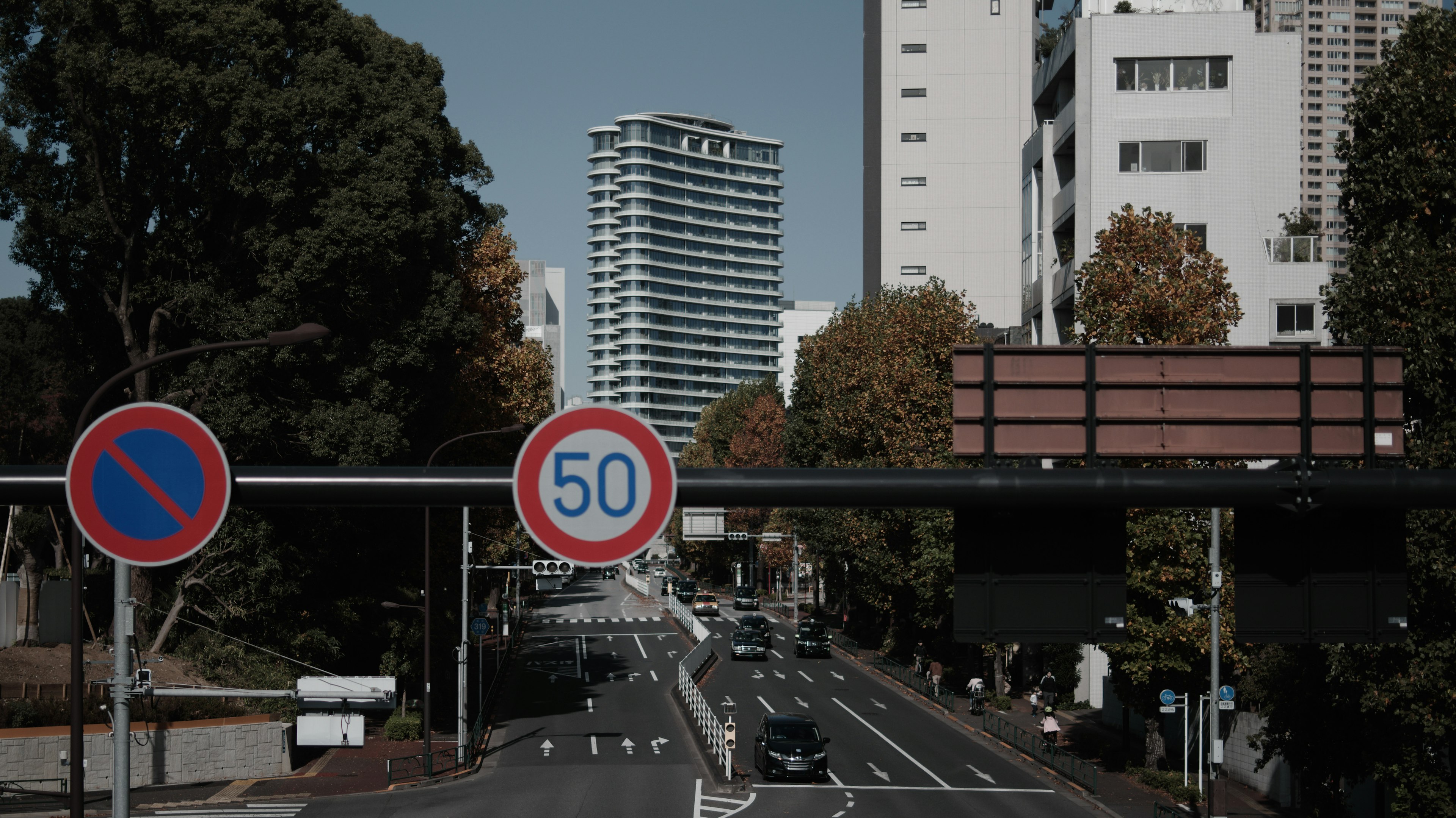 都市の道路に立つ交通標識とビル群