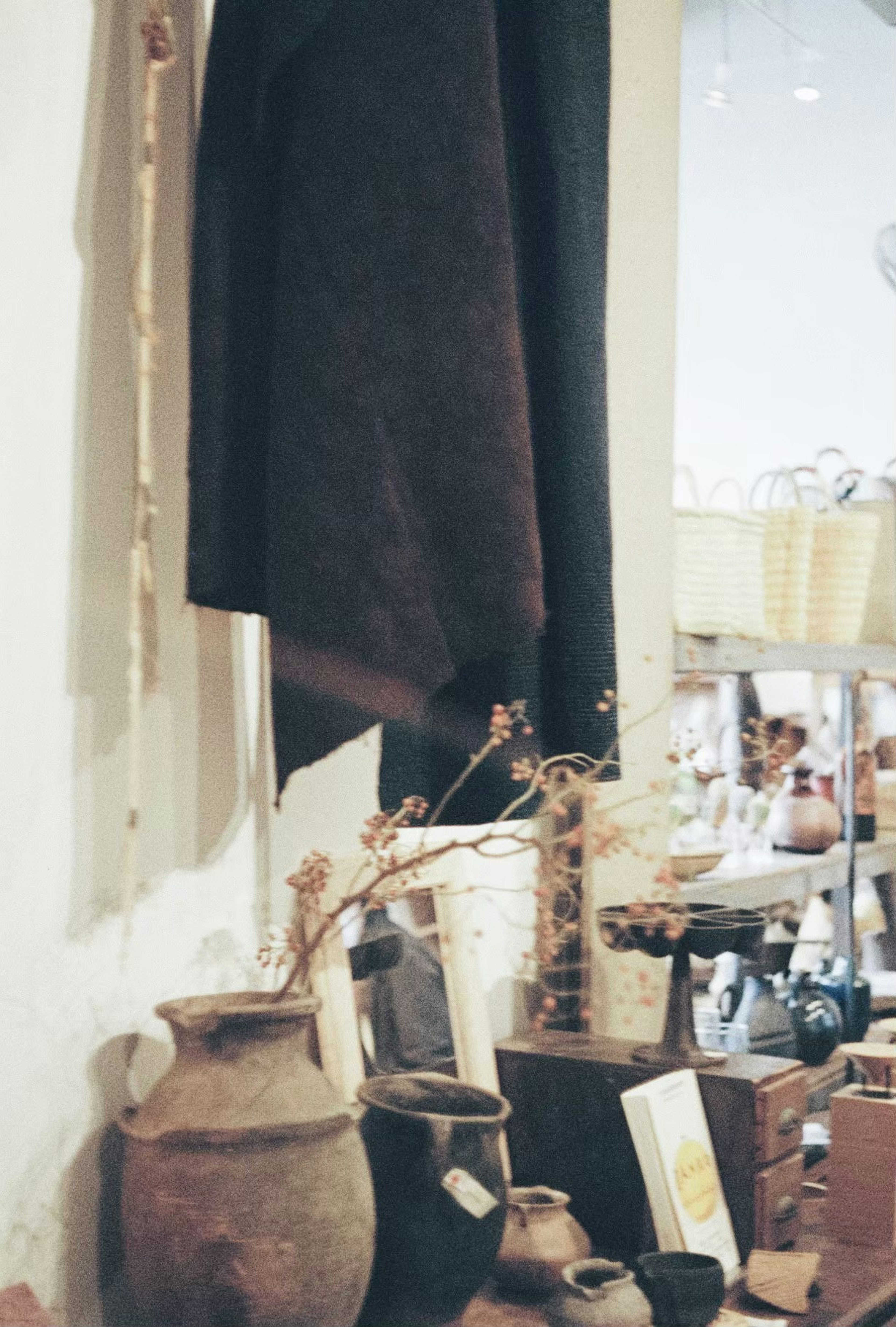 Affichage d'un tissu noir et de jarres en poterie dans un magasin