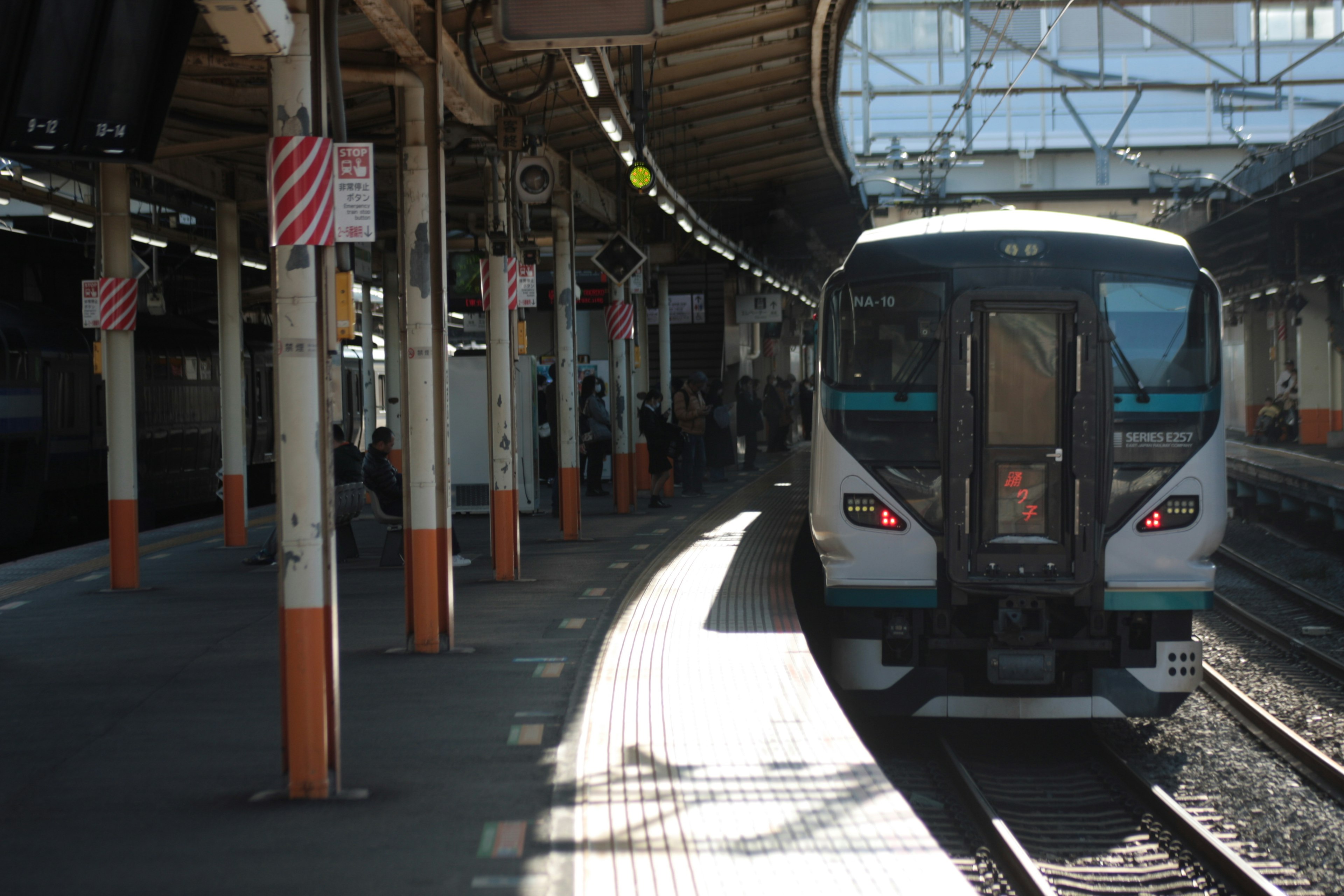 Train stopped at a station platform with contrasting shadows