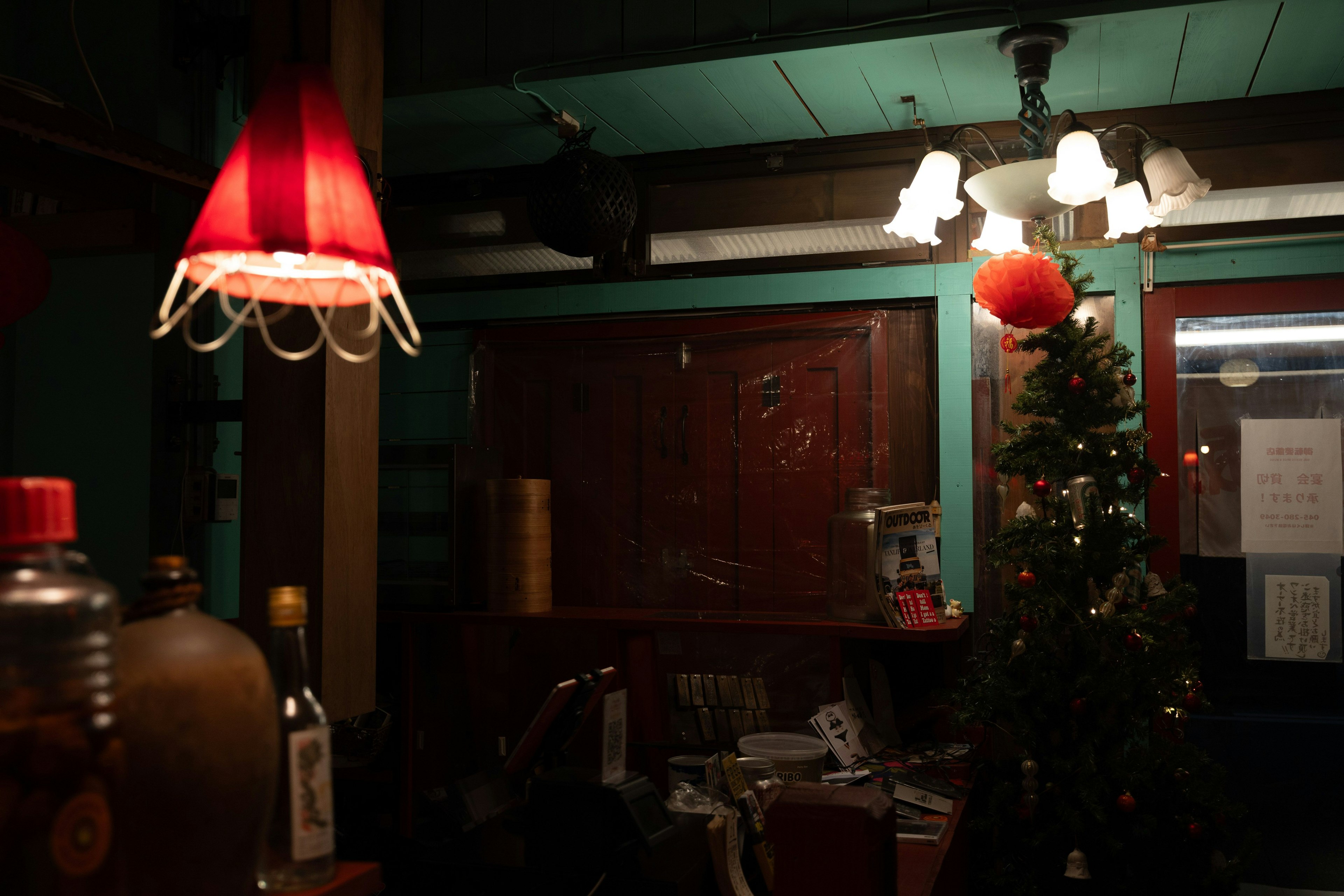 Gemütliches Interieur mit einem Weihnachtsbaum und roten Lampen
