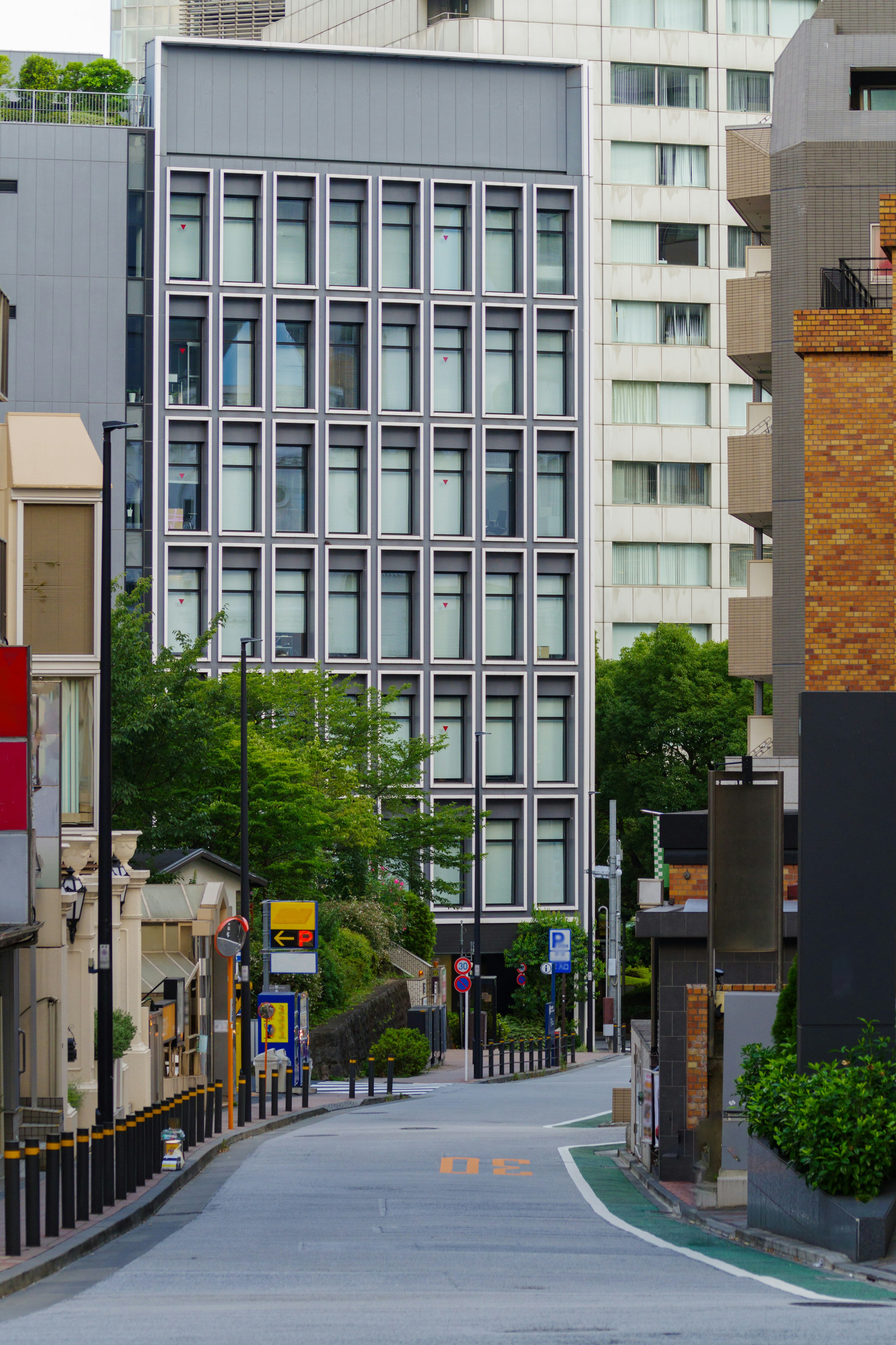 Städtische Straße umgeben von grünen Bäumen und modernen Gebäuden