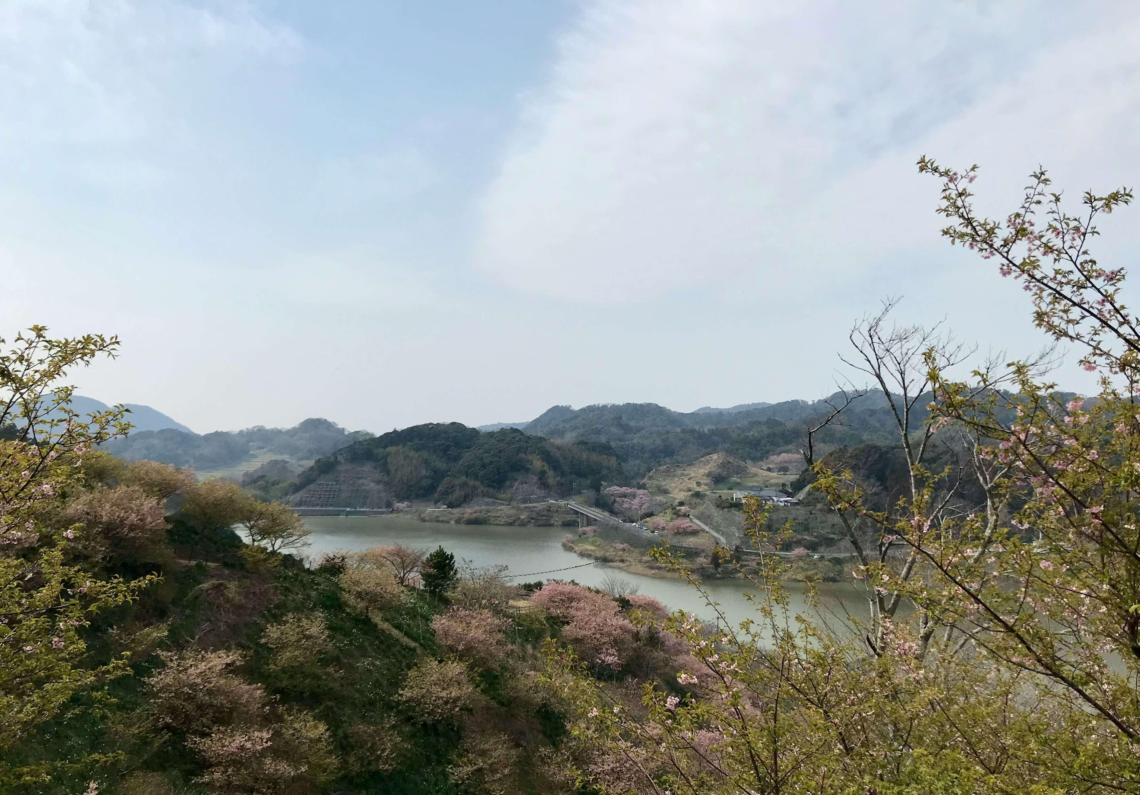 Scenic view of mountains and a river under a cloudy sky