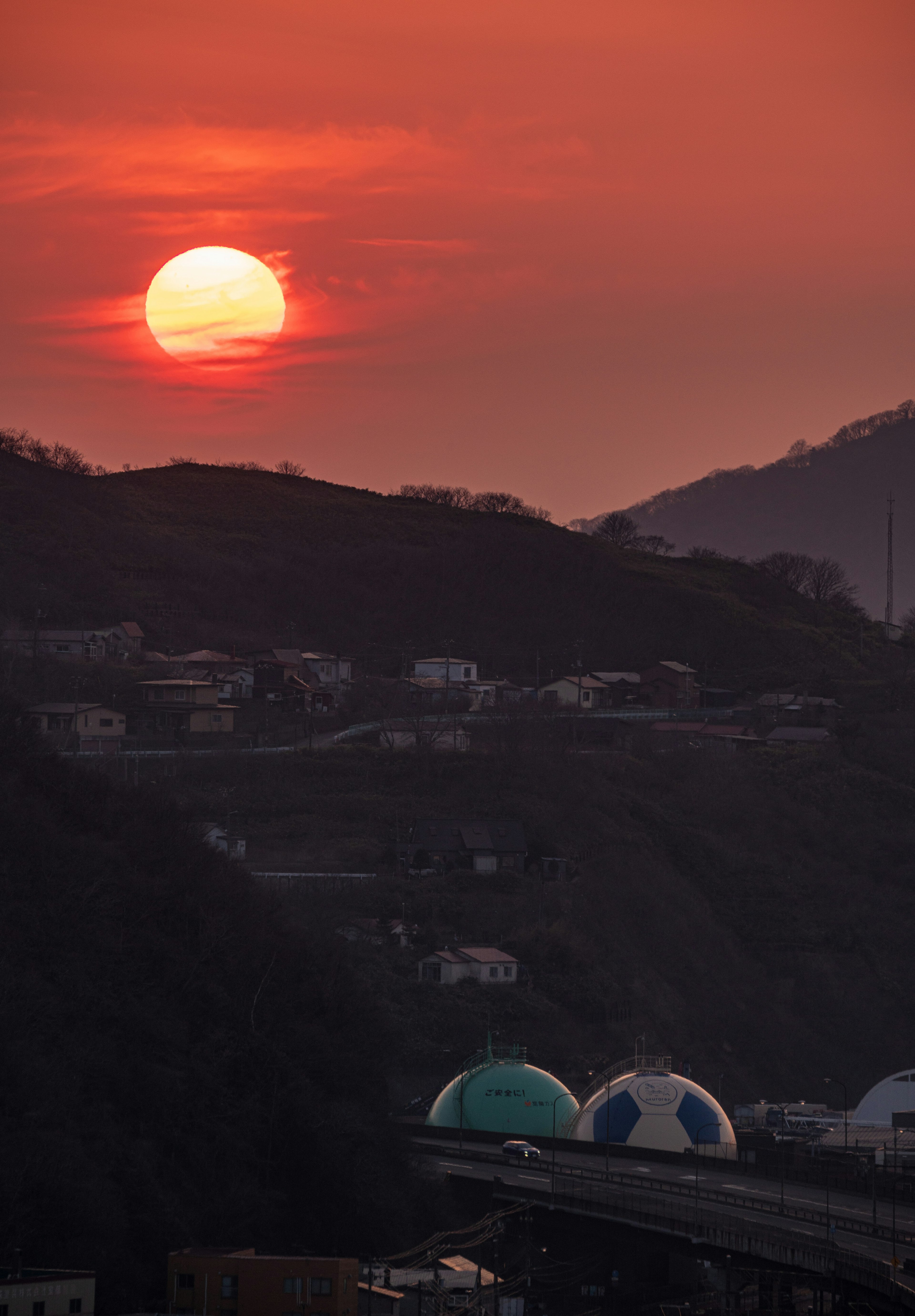 夕日が沈む山々の風景と青いドームの建物