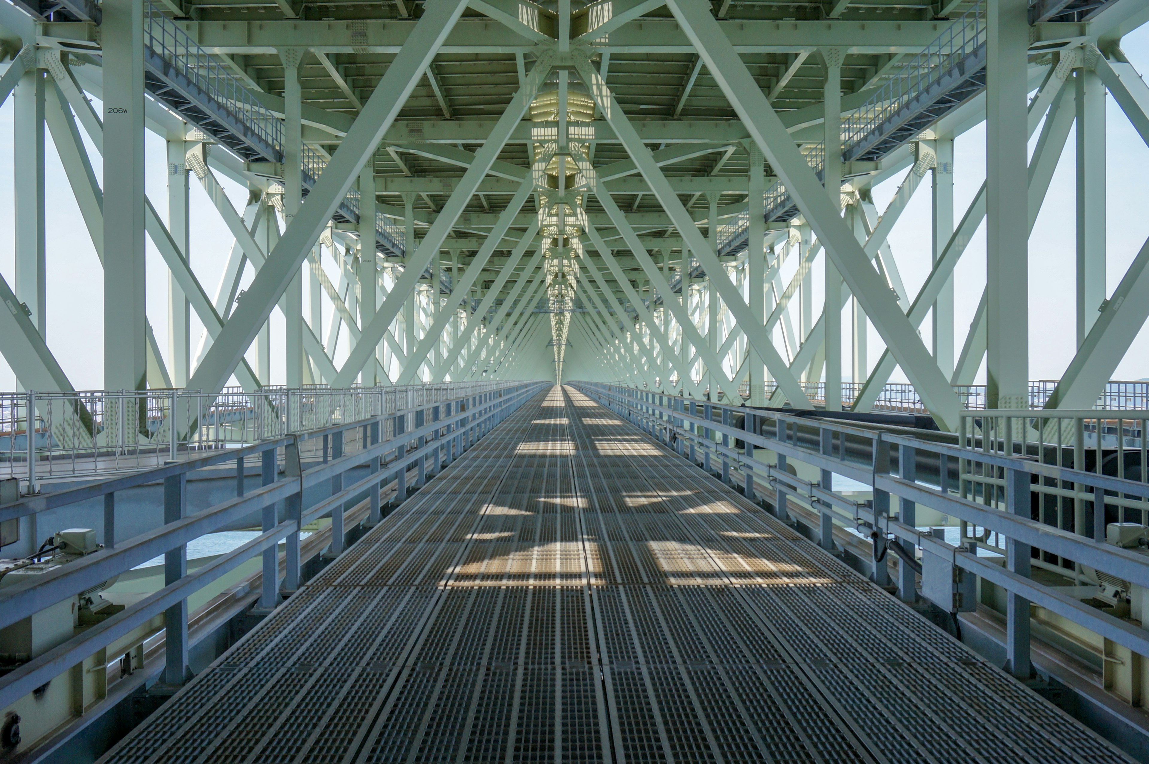 Long corridor viewed from underneath a railway bridge with structural supports