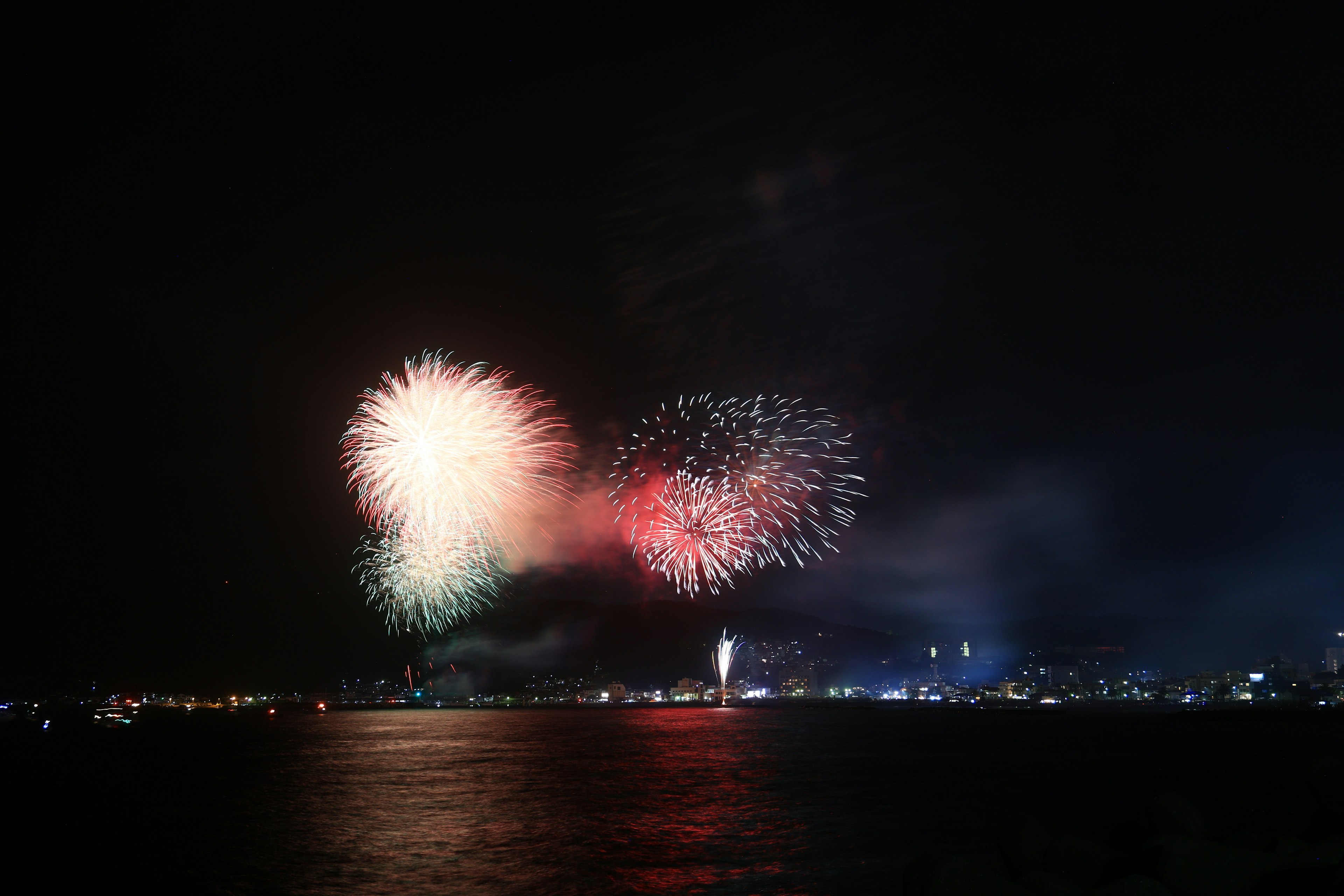 Wunderschönes Feuerwerk erhellt den Nachthimmel über dem Wasser