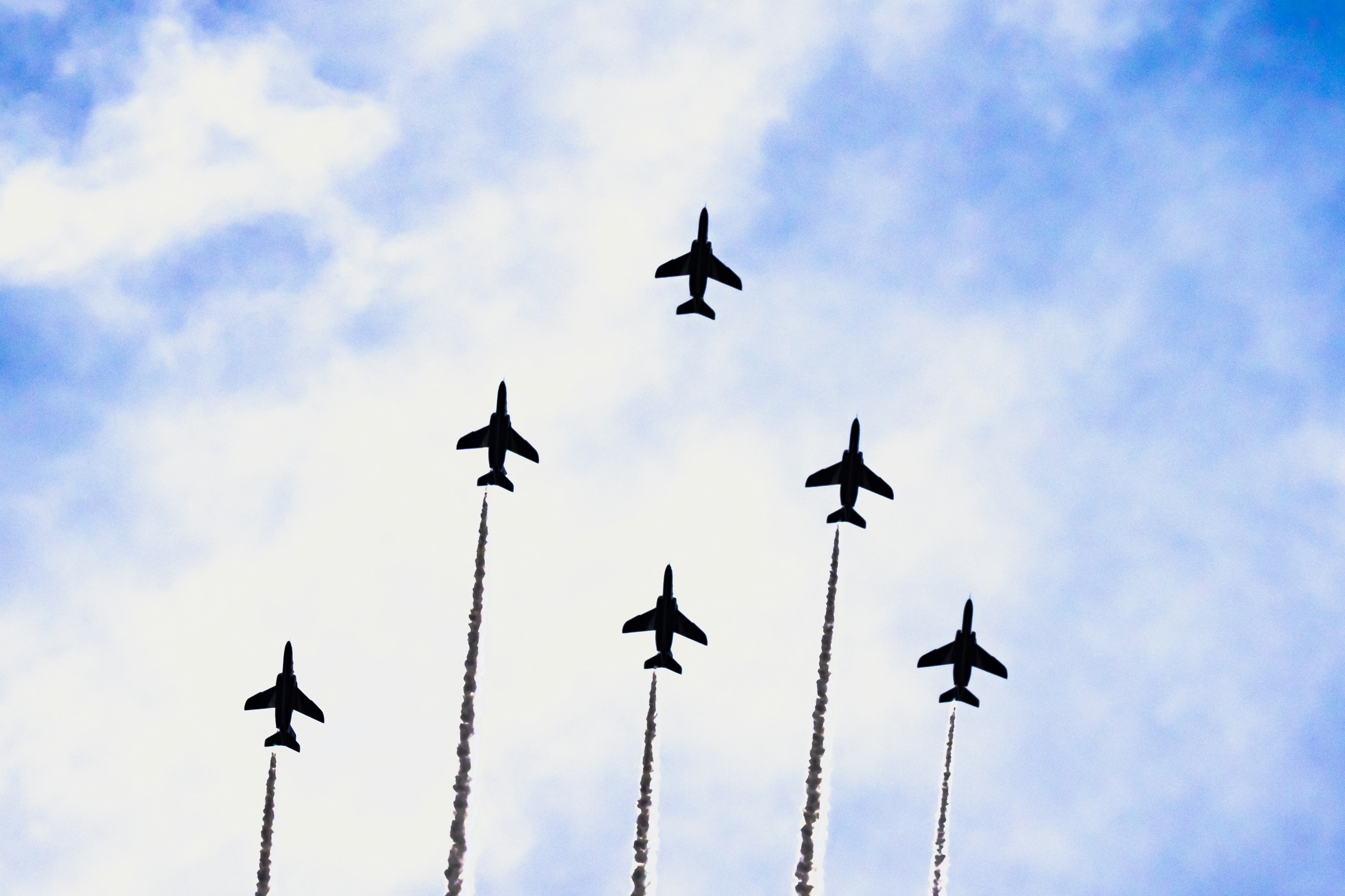 Sechs Flugzeuge steigen in den Himmel und hinterlassen Rauchspuren