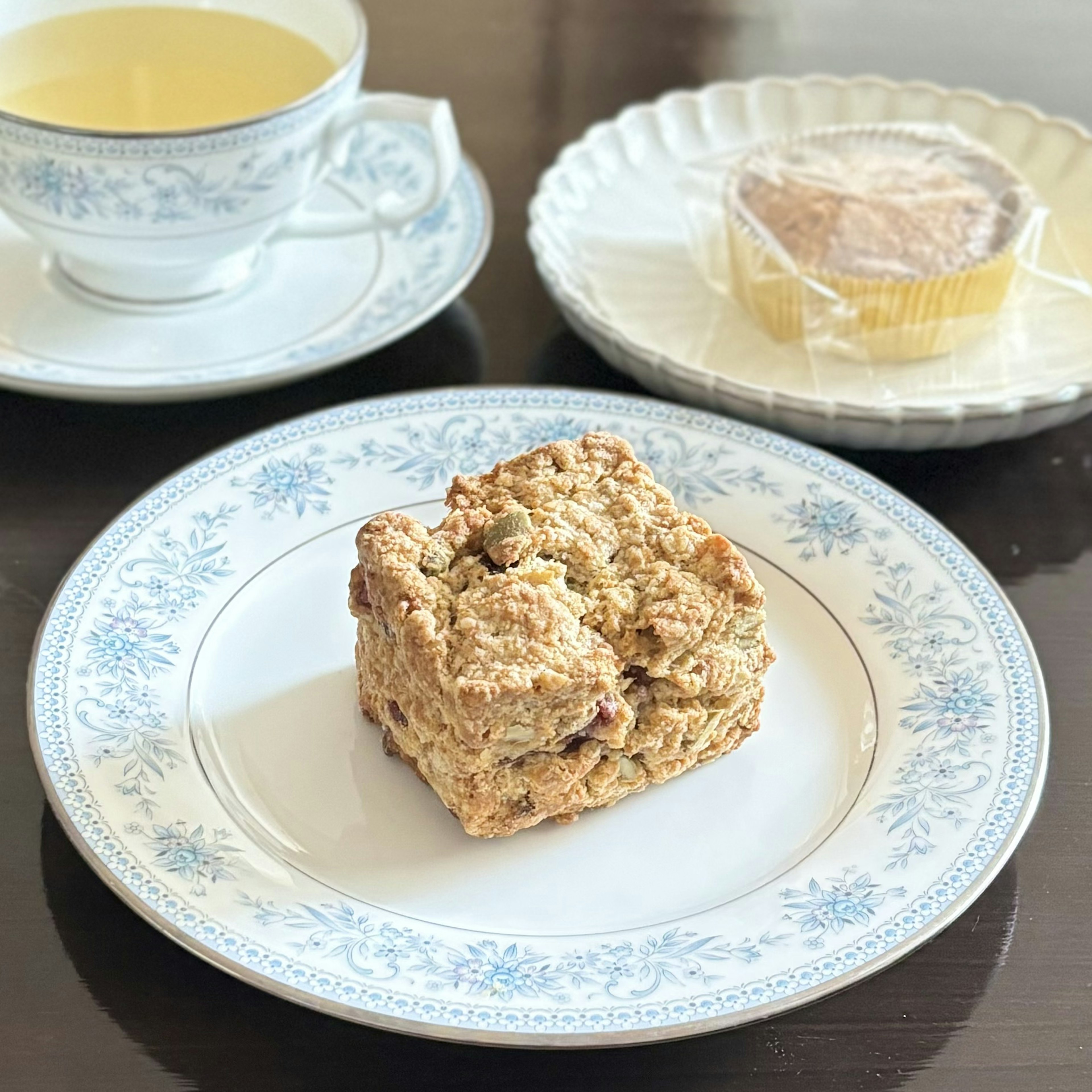 Teh dengan scone dan makanan penutup di piring dekoratif