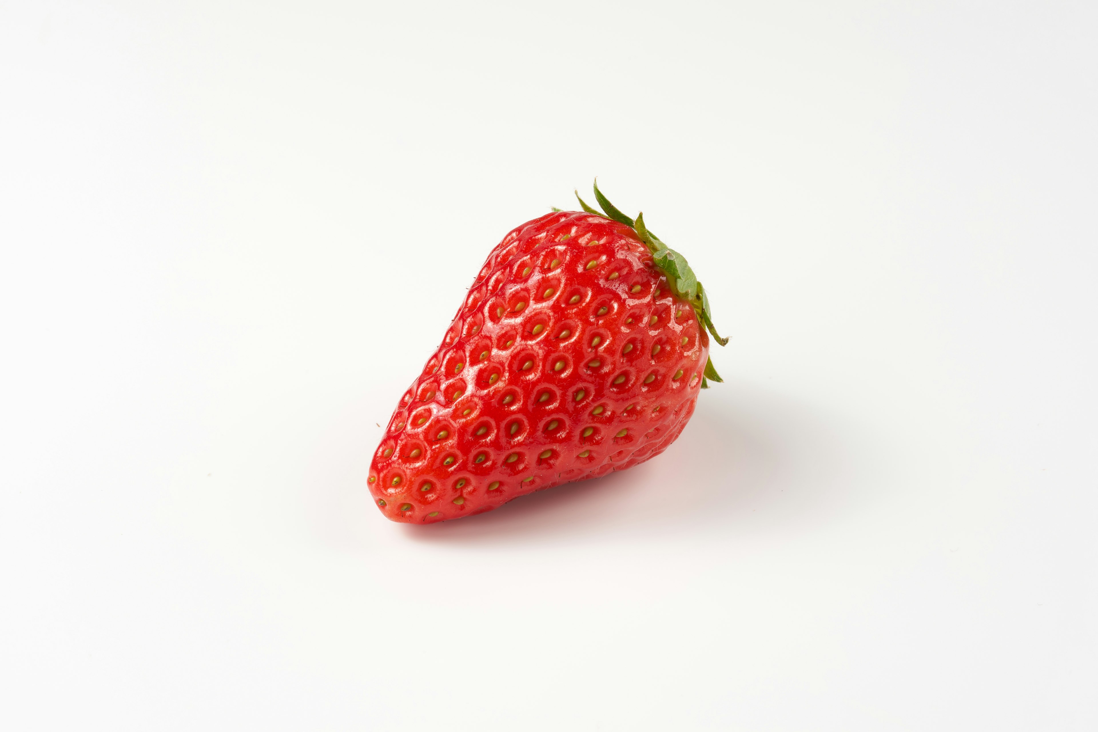 A fresh strawberry placed on a white background