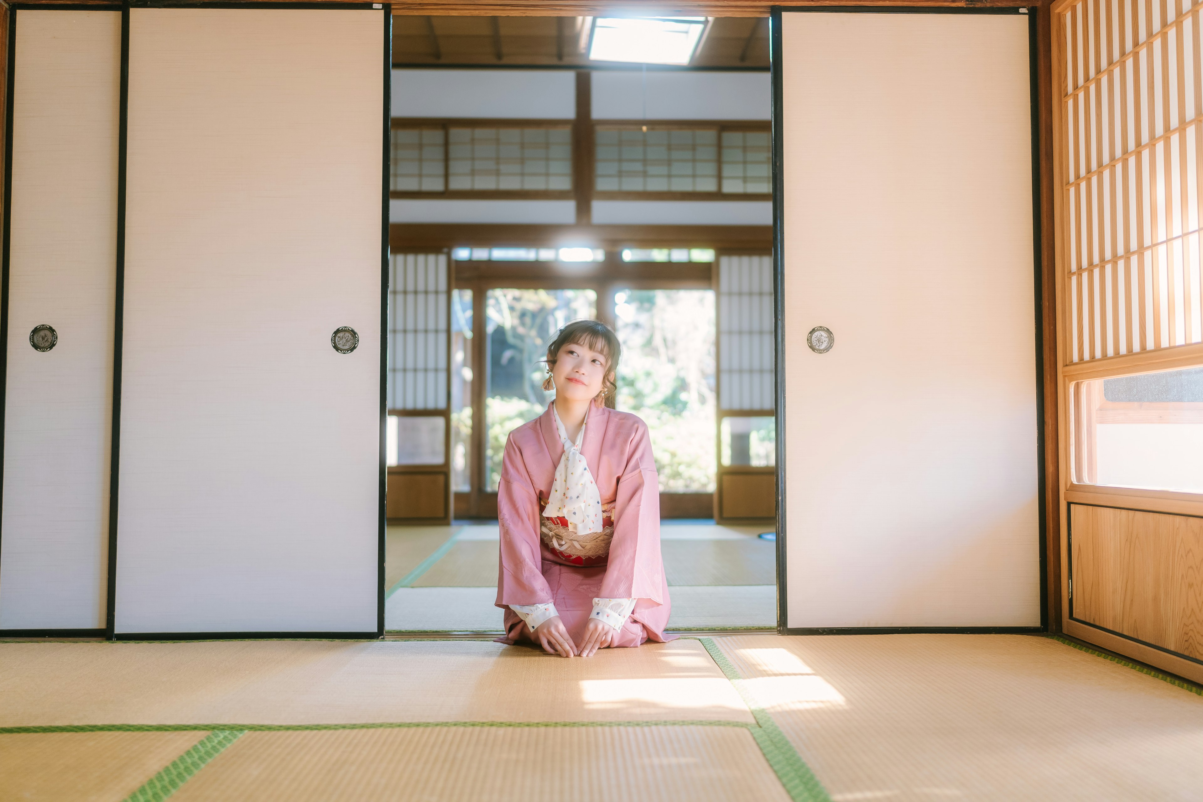 Seorang wanita mengenakan kimono duduk di ruang tradisional Jepang