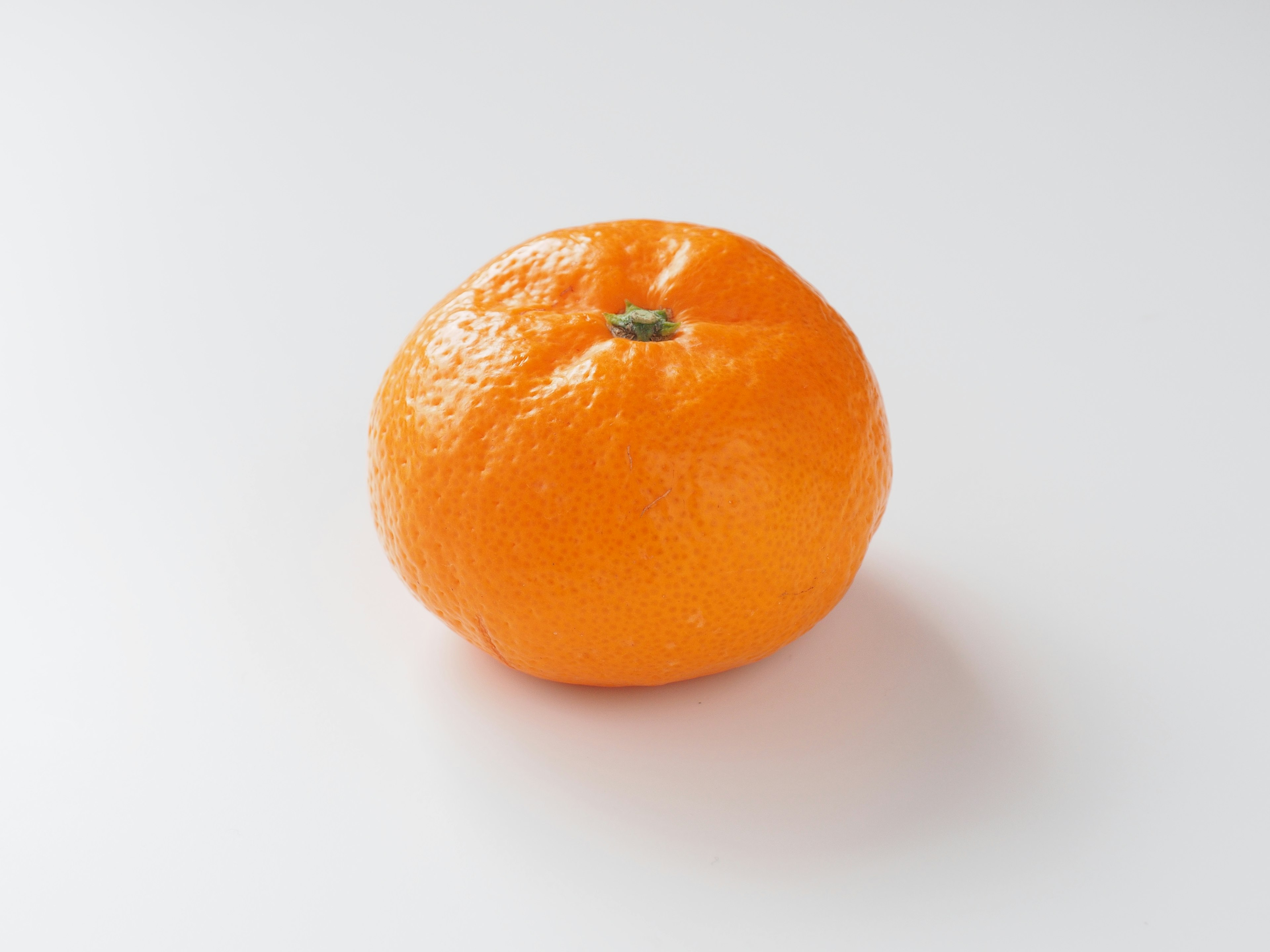 Une mandarine orange vif sur un fond blanc