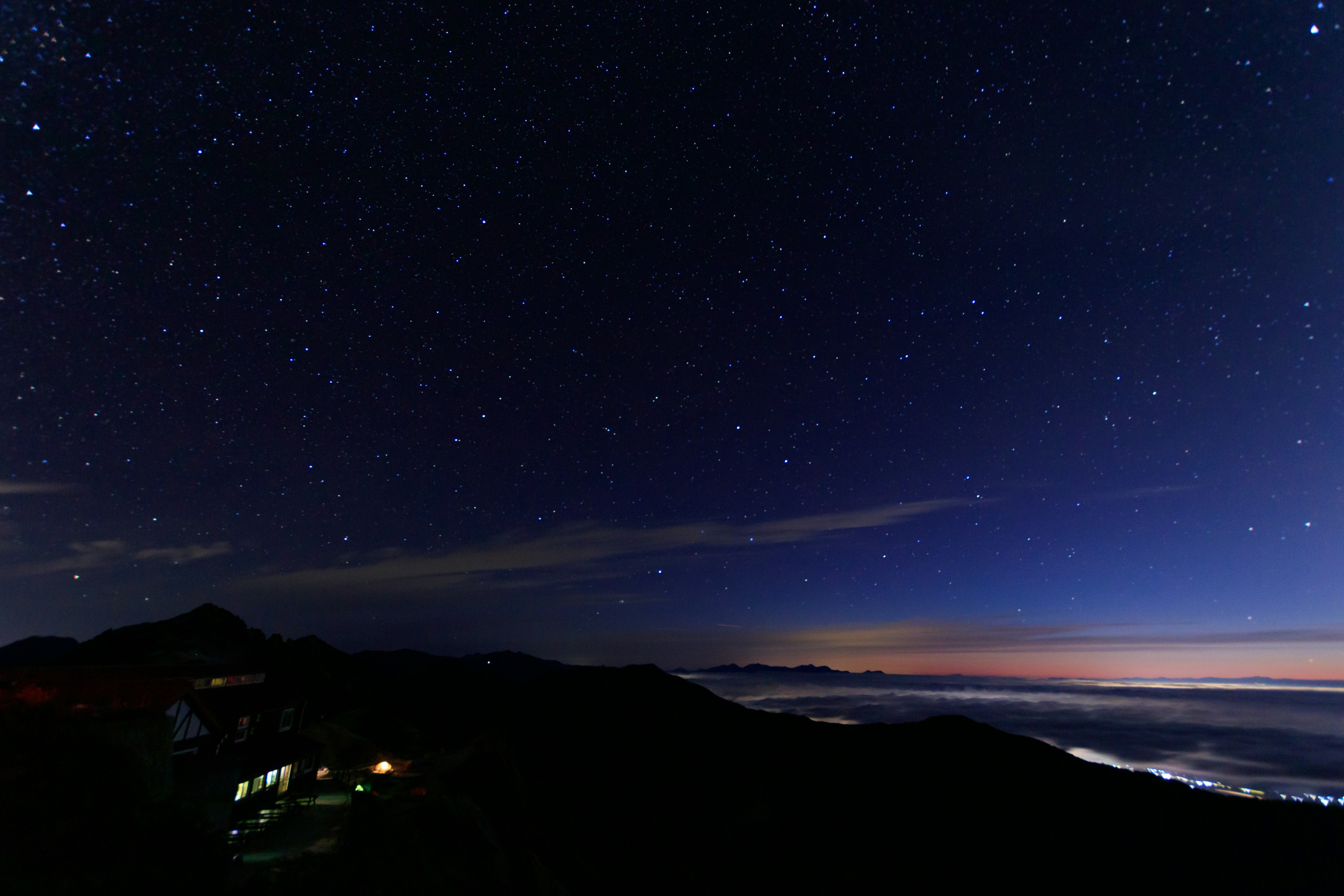 美丽的夜空中布满星星和远处的海洋灯光