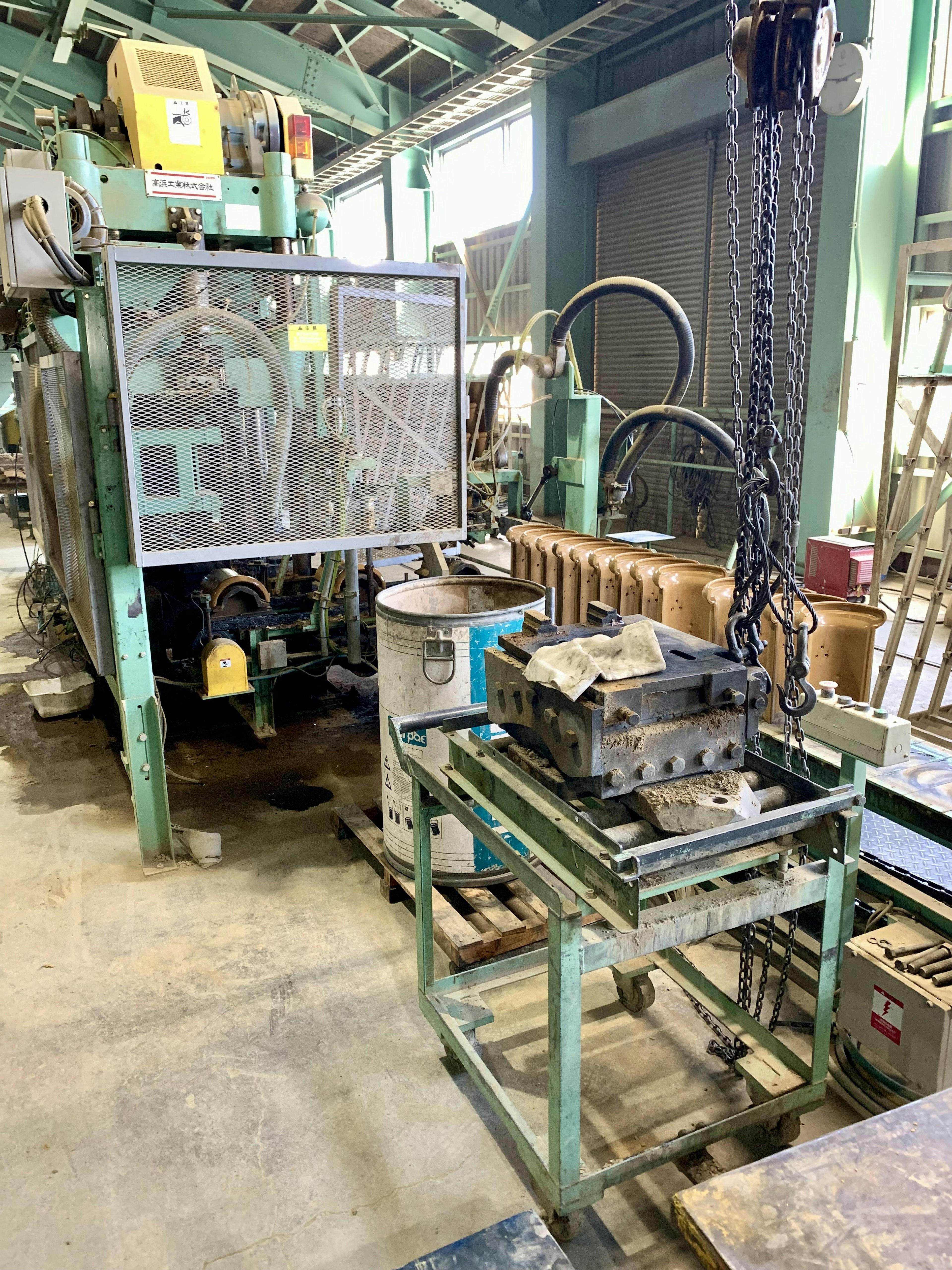 Photo of machinery and transport equipment in a factory featuring a monitor on the side and a workbench