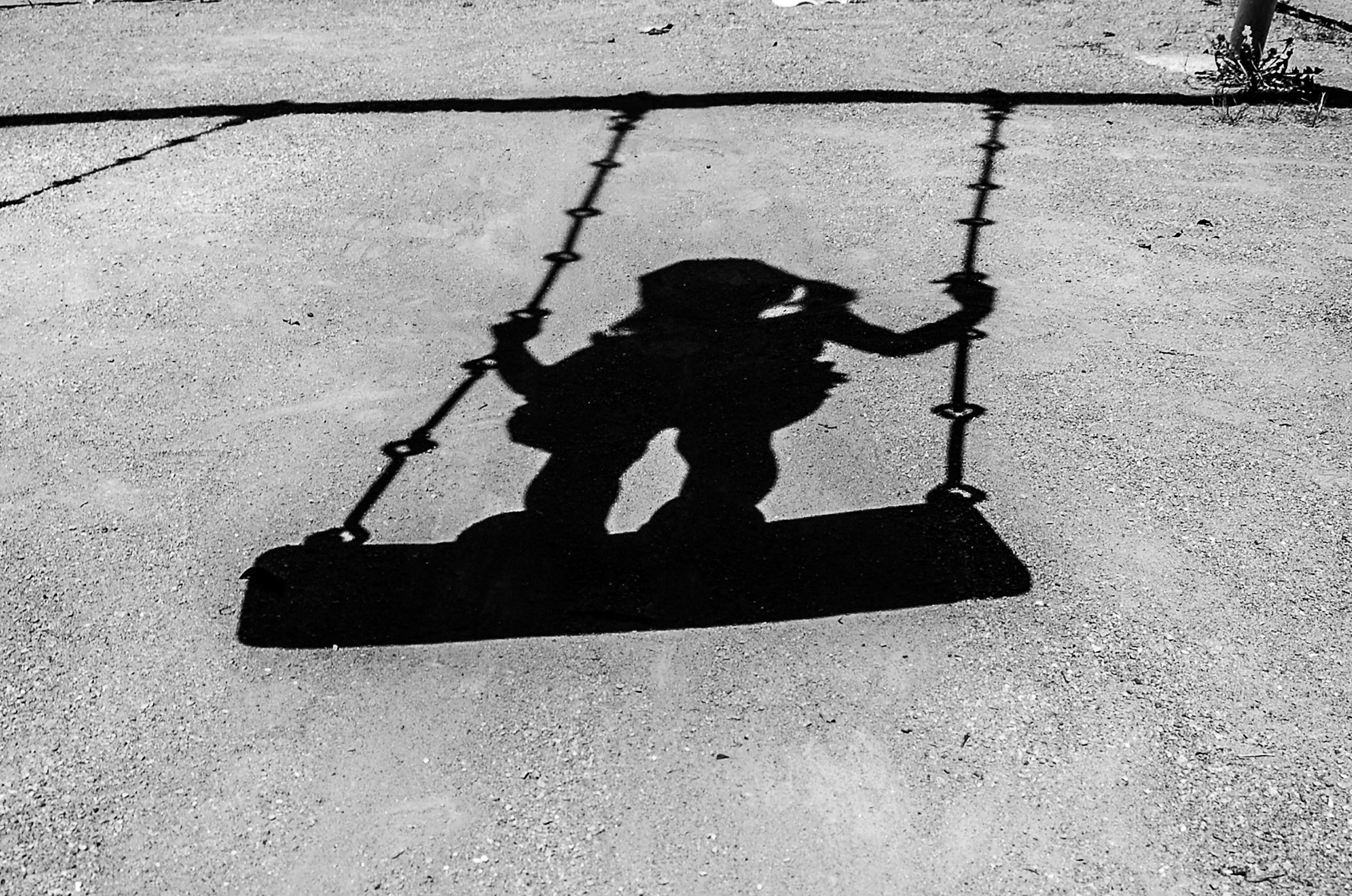 Silhouette of a person sitting on a black swing