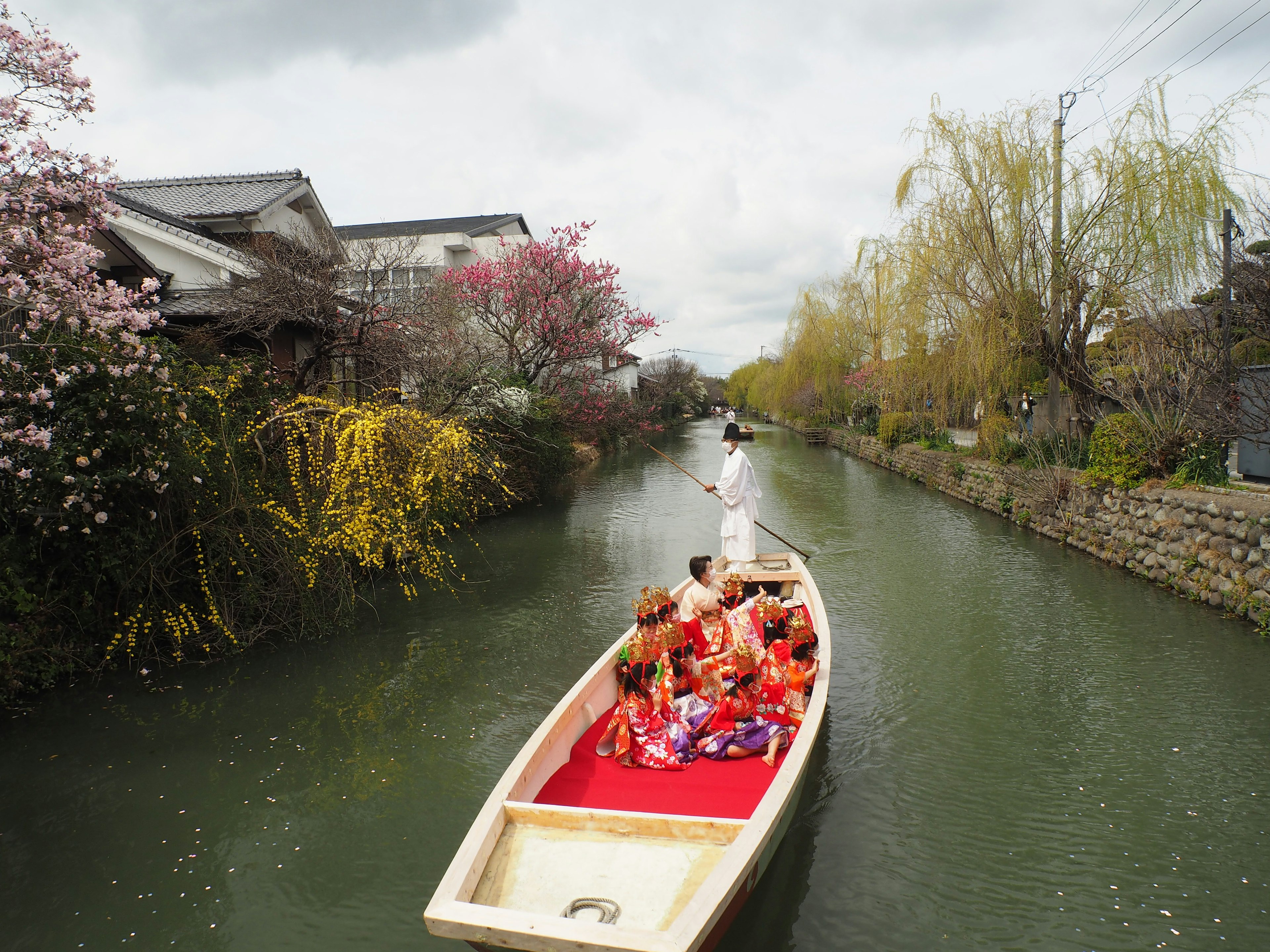 Un bote pintoresco en un río rodeado de cerezos en flor y vegetación