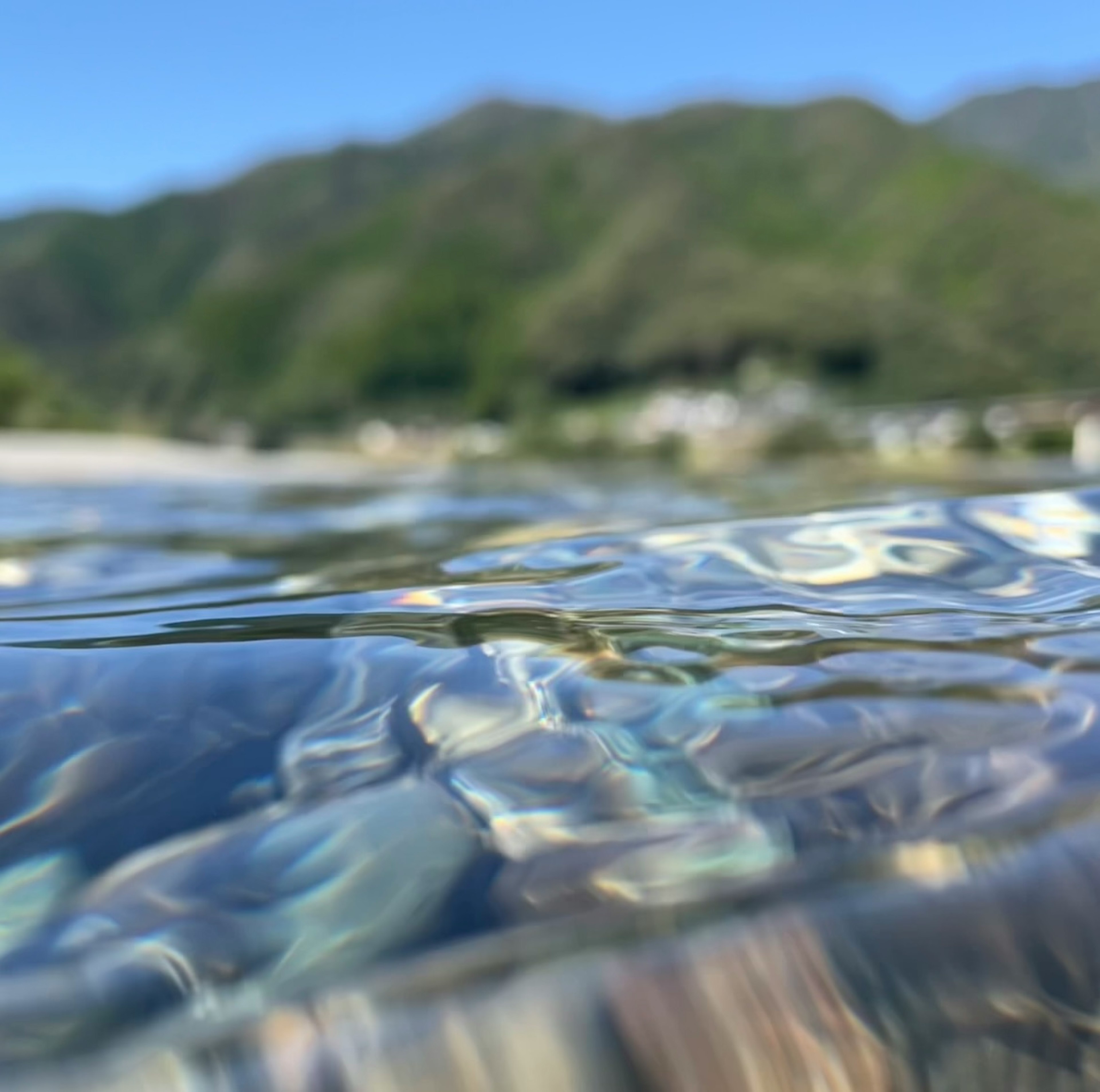 水面の下にある透明な水と山々の風景