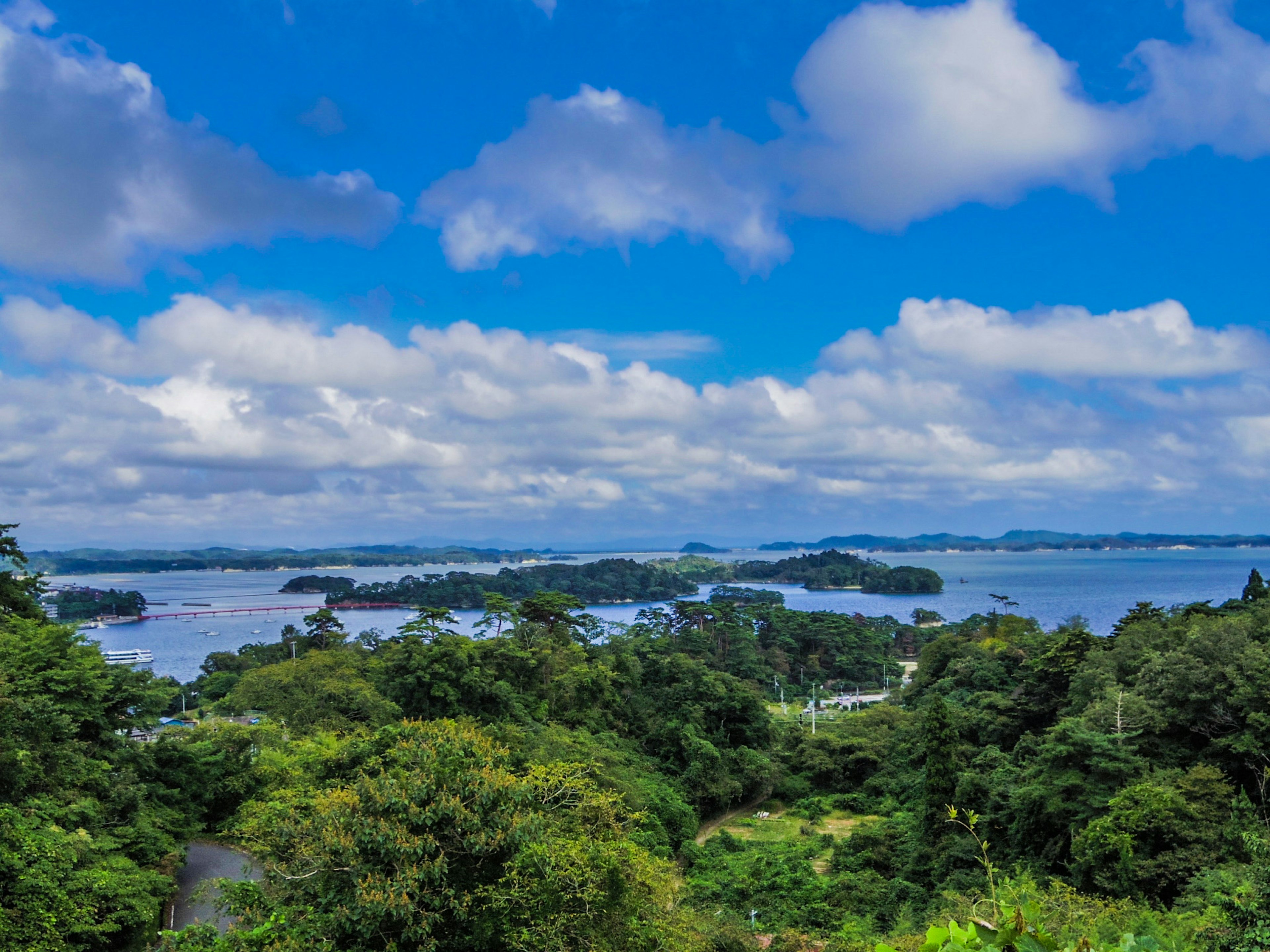 Vue pittoresque d'îles verdoyantes sous un ciel bleu avec des nuages blancs