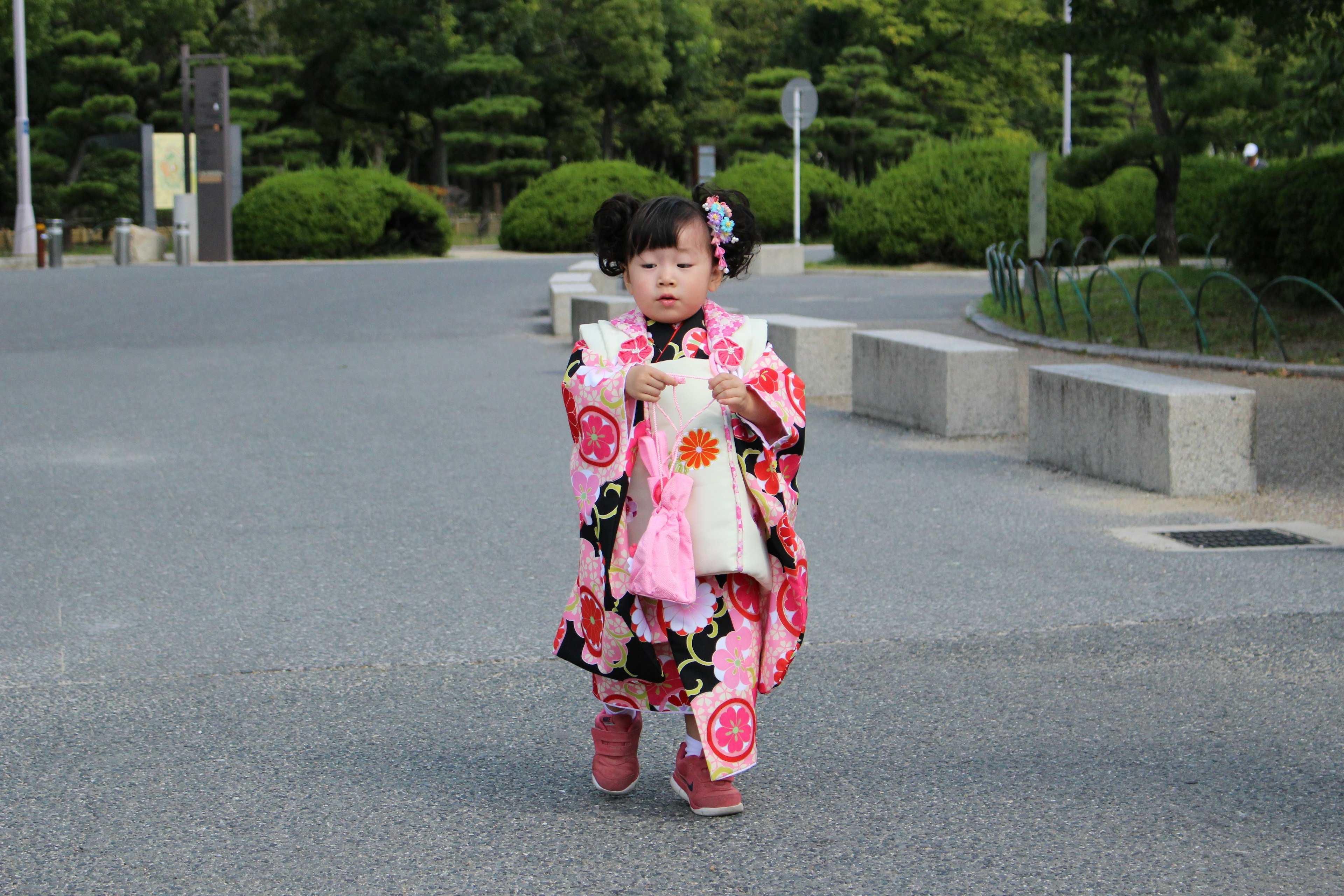 Une petite fille en kimono marchant dans un parc