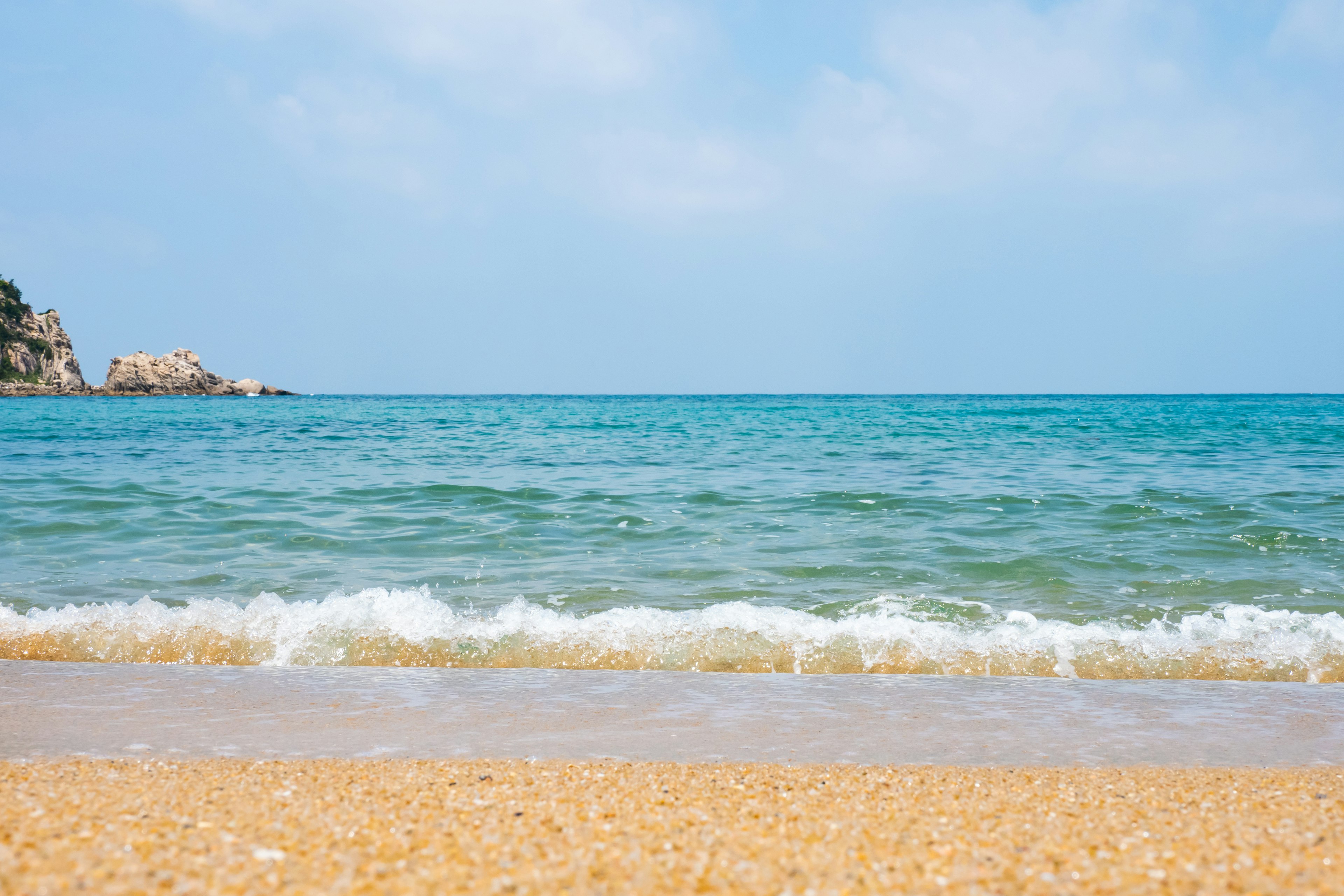 Vue panoramique de l'océan bleu avec une plage de sable et des vagues douces