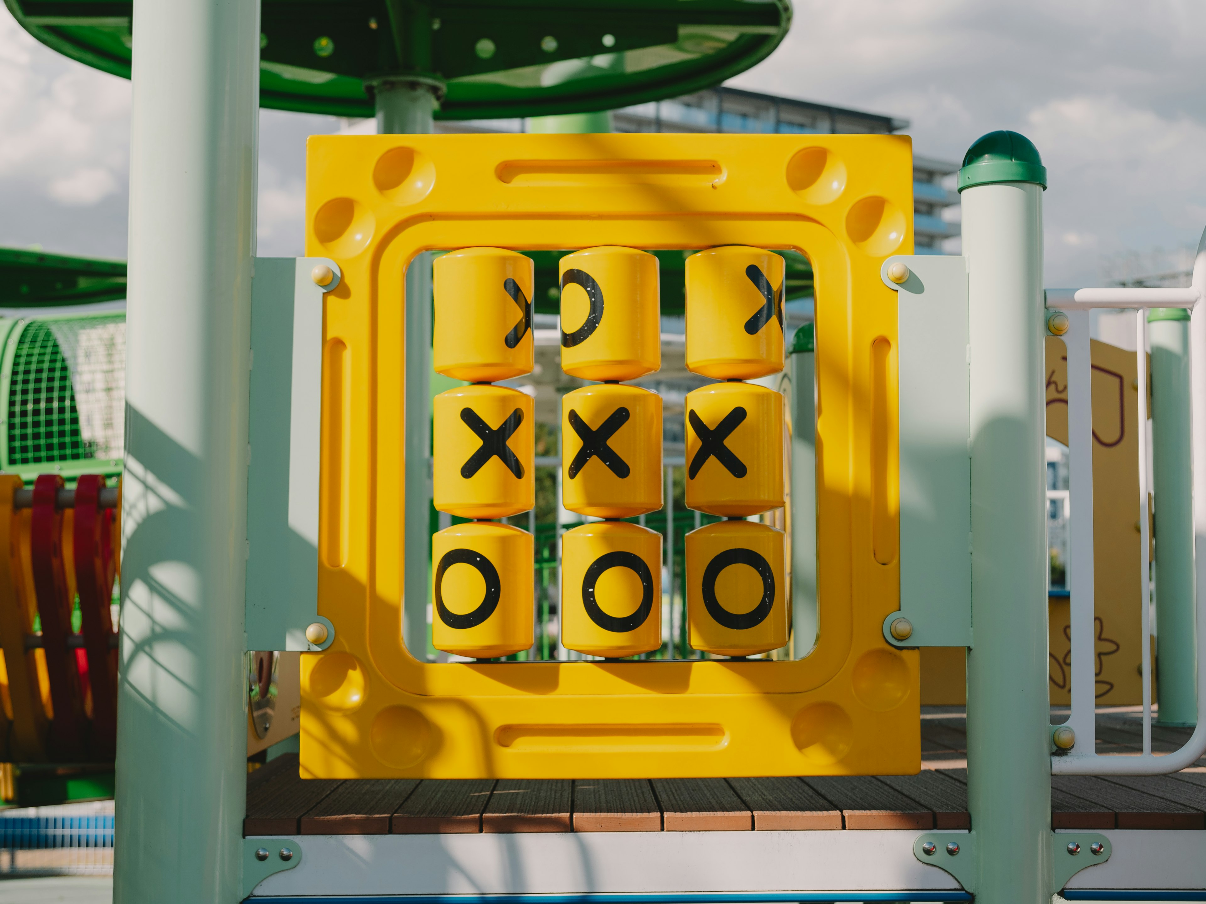 Yellow tic-tac-toe game structure in a playground