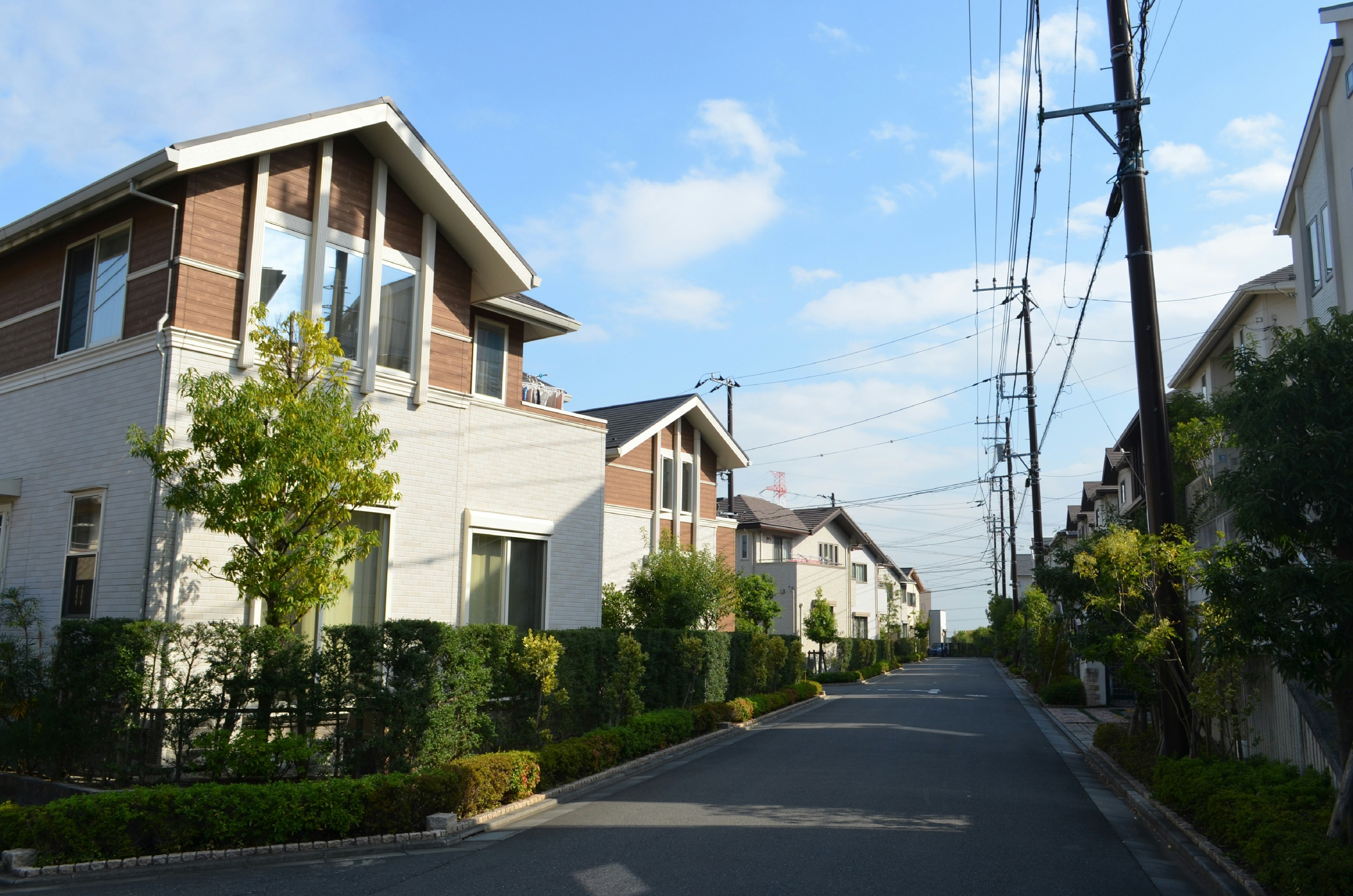 Casas modernas alineadas en una calle residencial tranquila bajo un cielo azul