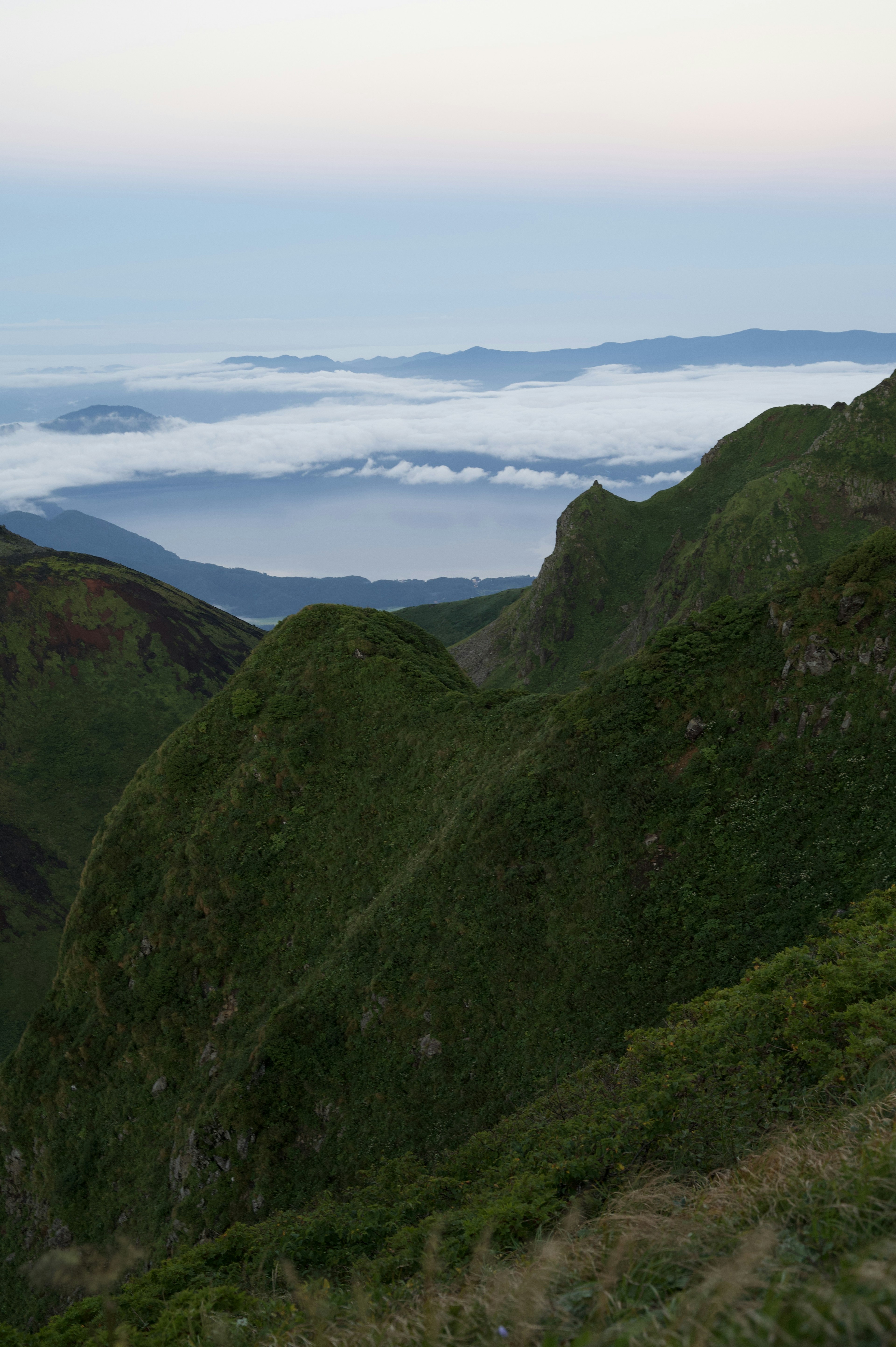 Montañas verdes con un mar de nubes